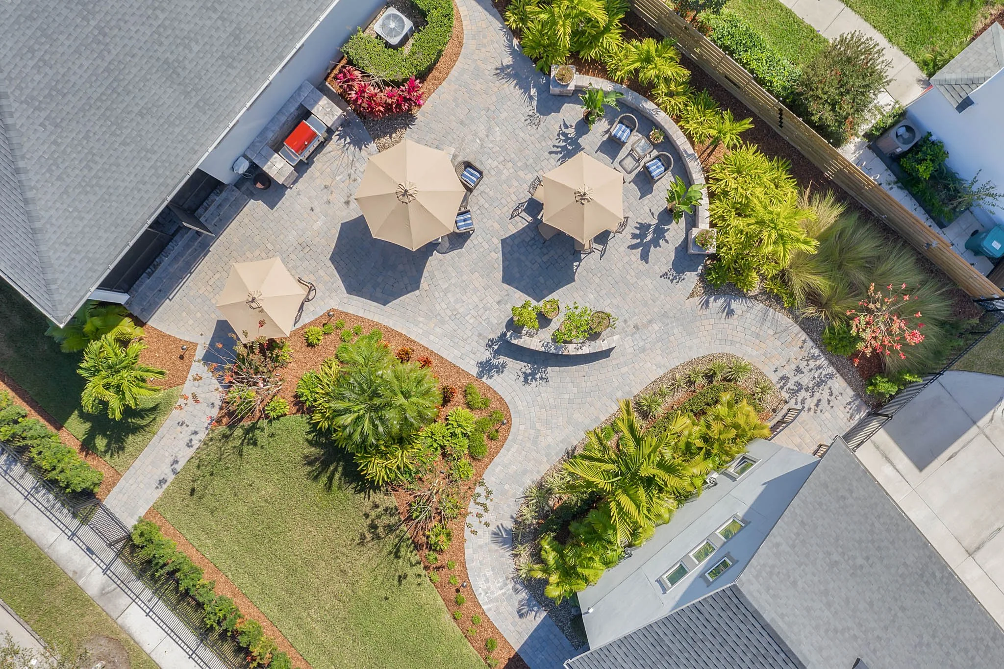 Pavers and Back yard outdoor living with beautiful tropical landscaping provided by Kasa Landscape