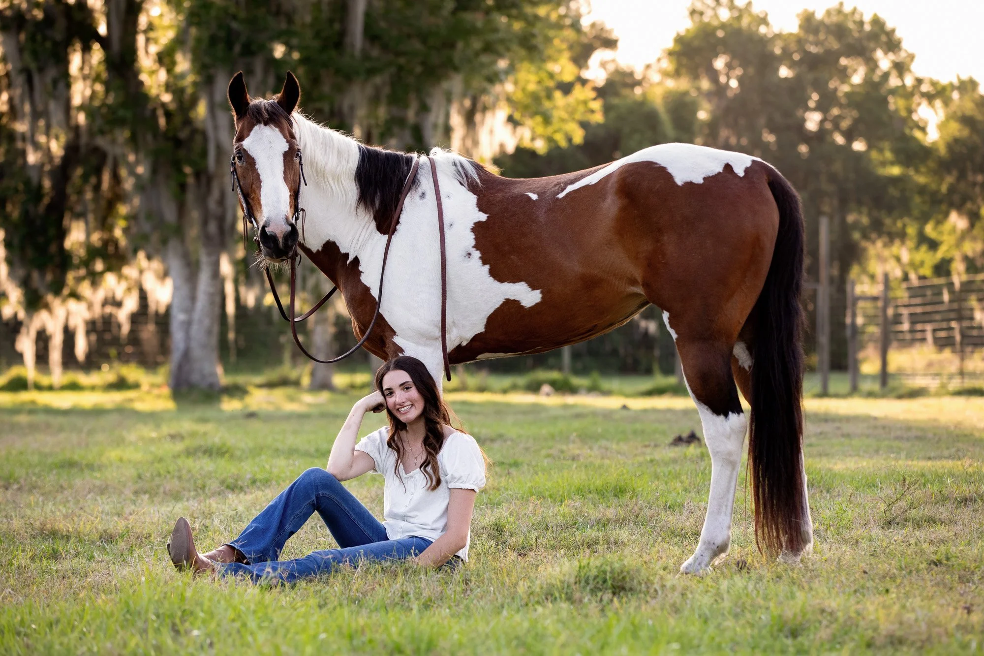 girl sitting in front of her pinto pony