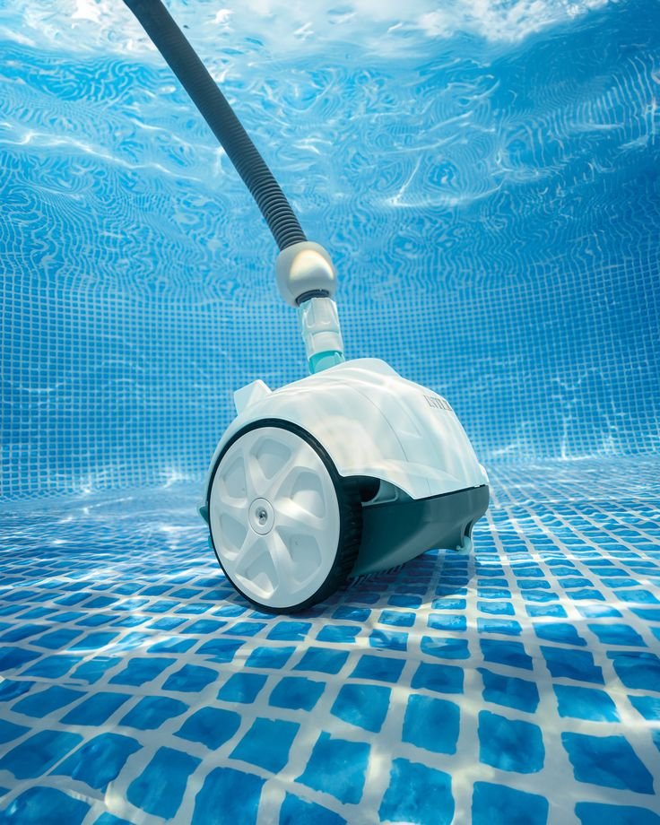 A robotic pool cleaner on the bottom of a swimming pool with blue tile walls and floor.