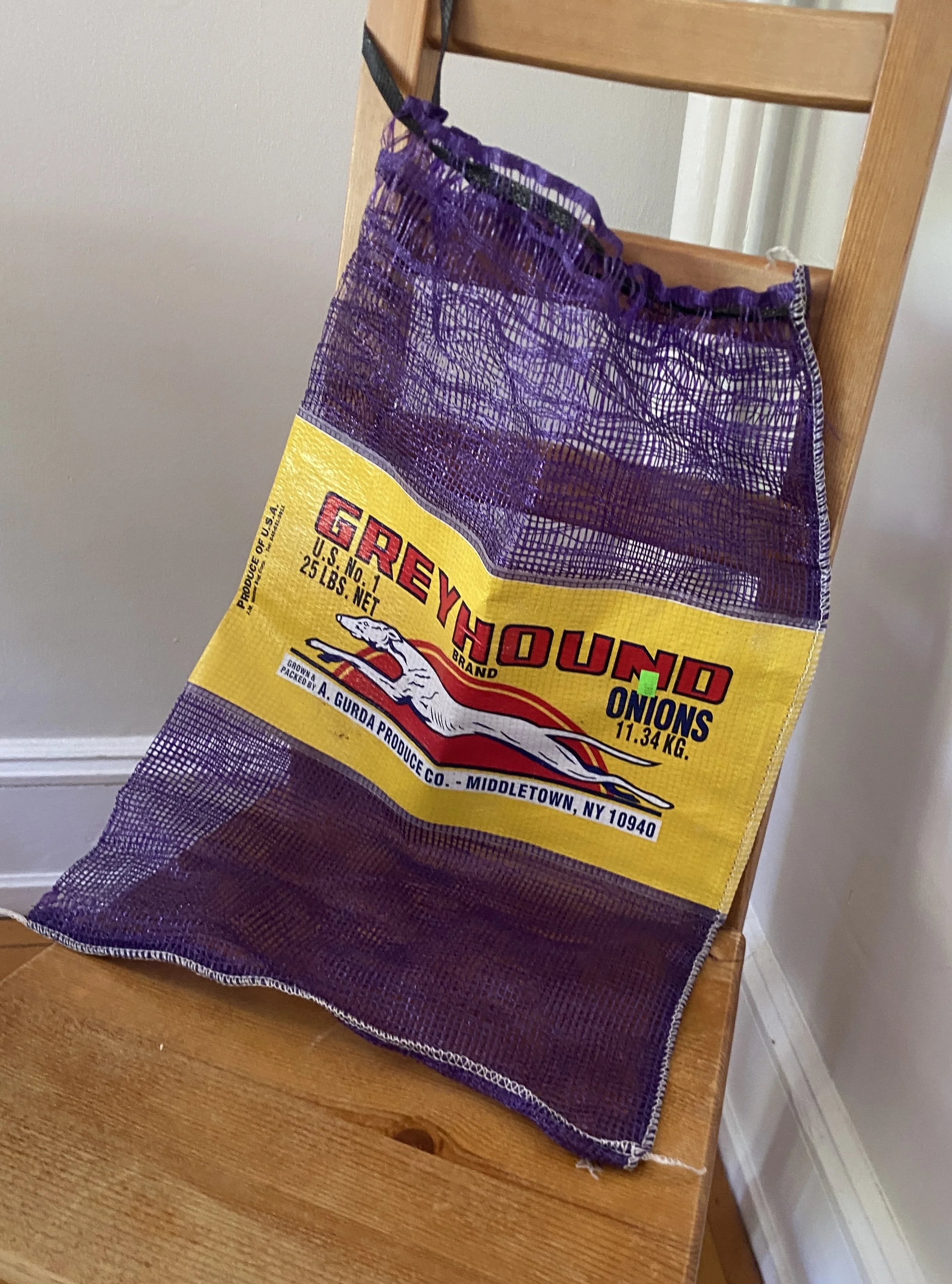 Purple Onion Bag with a Yellow Label with a Greyhound on it