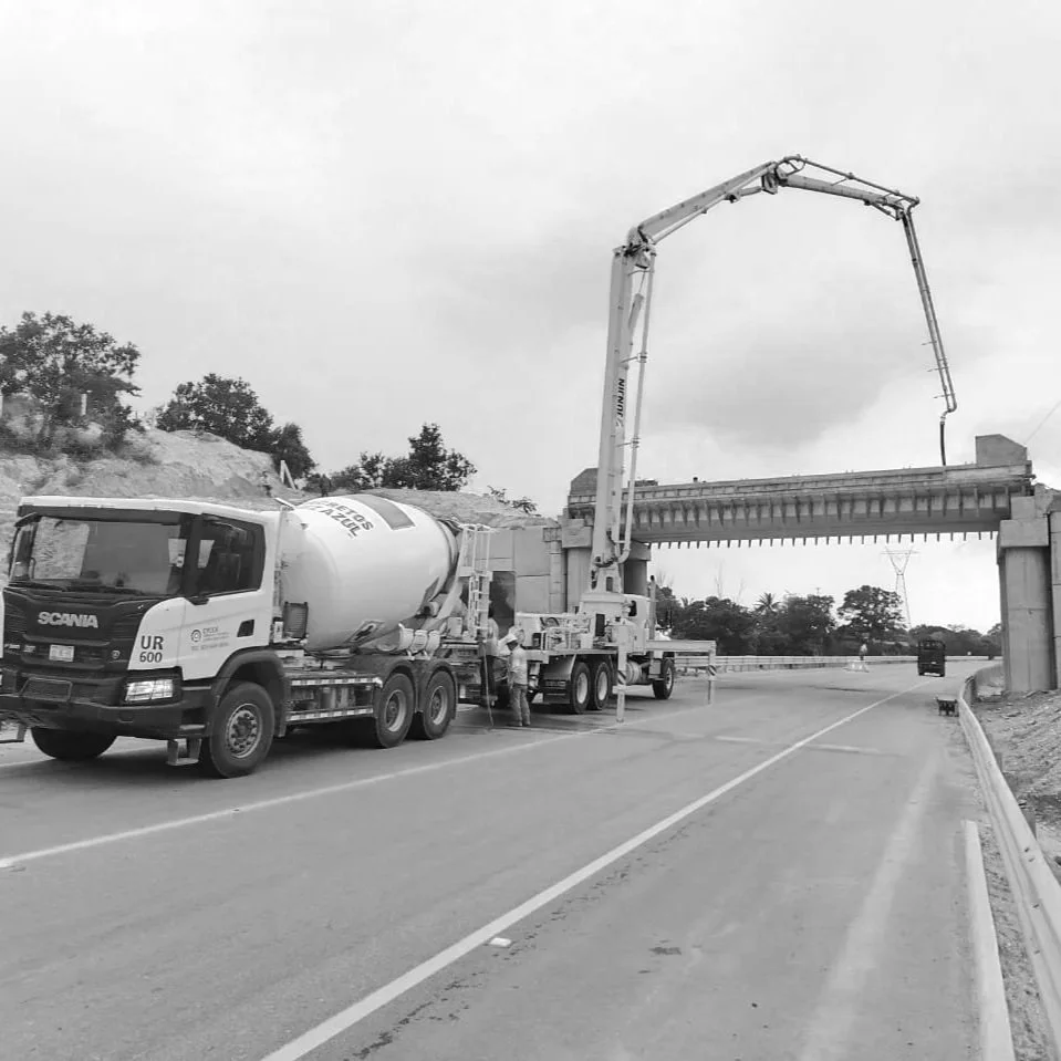 Camiones trabajando en la construcción de un puente en la carretera.