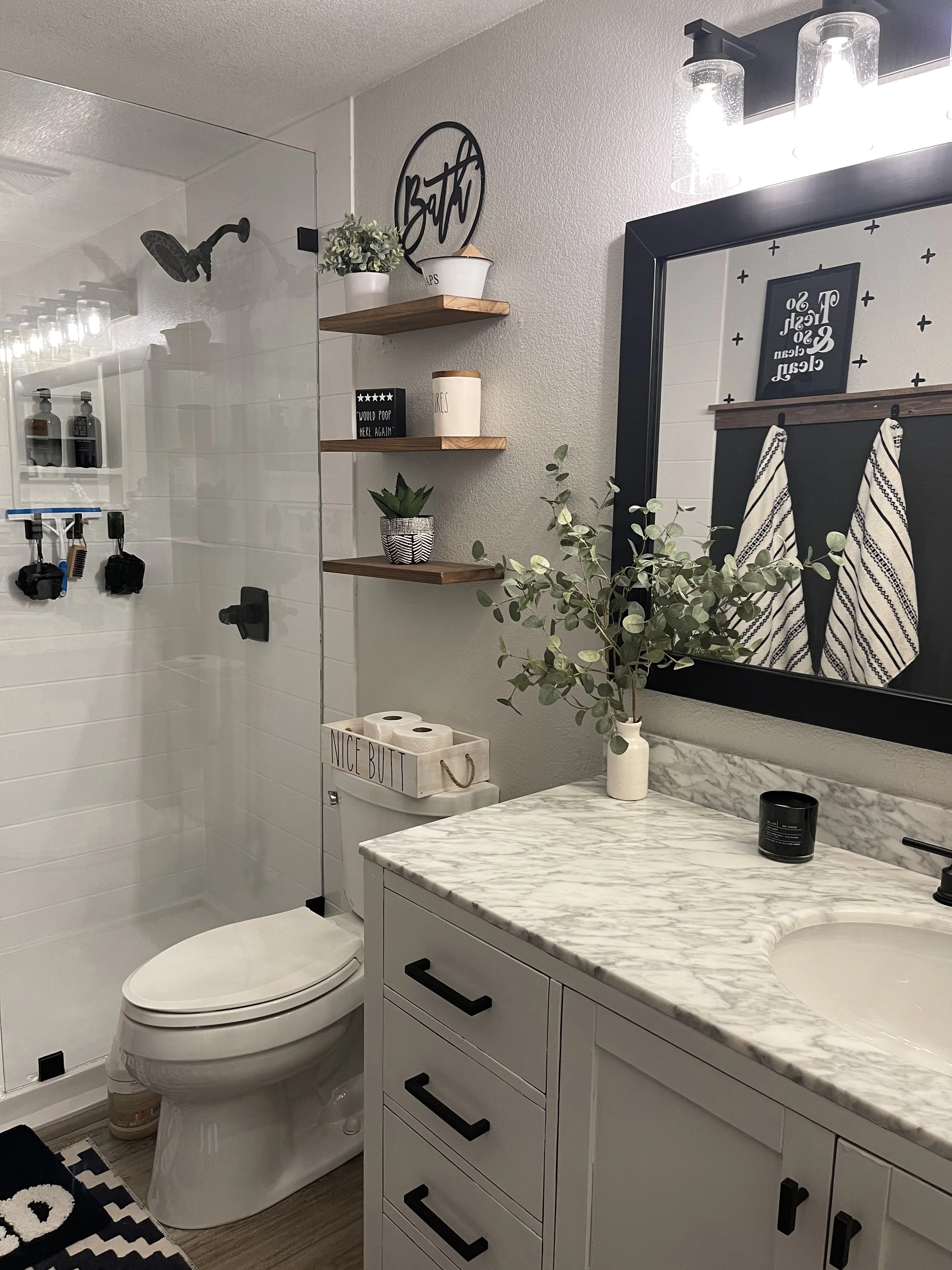 Spacious walk-in shower remodel featuring bench seating, block privacy window, recessed niche shelving, and low-threshold entry