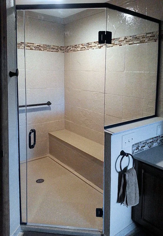 Custom walk-in shower with glass enclosure, built-in bench, grab bars, and accessibility features for a safety-focused bathroom upgrade.