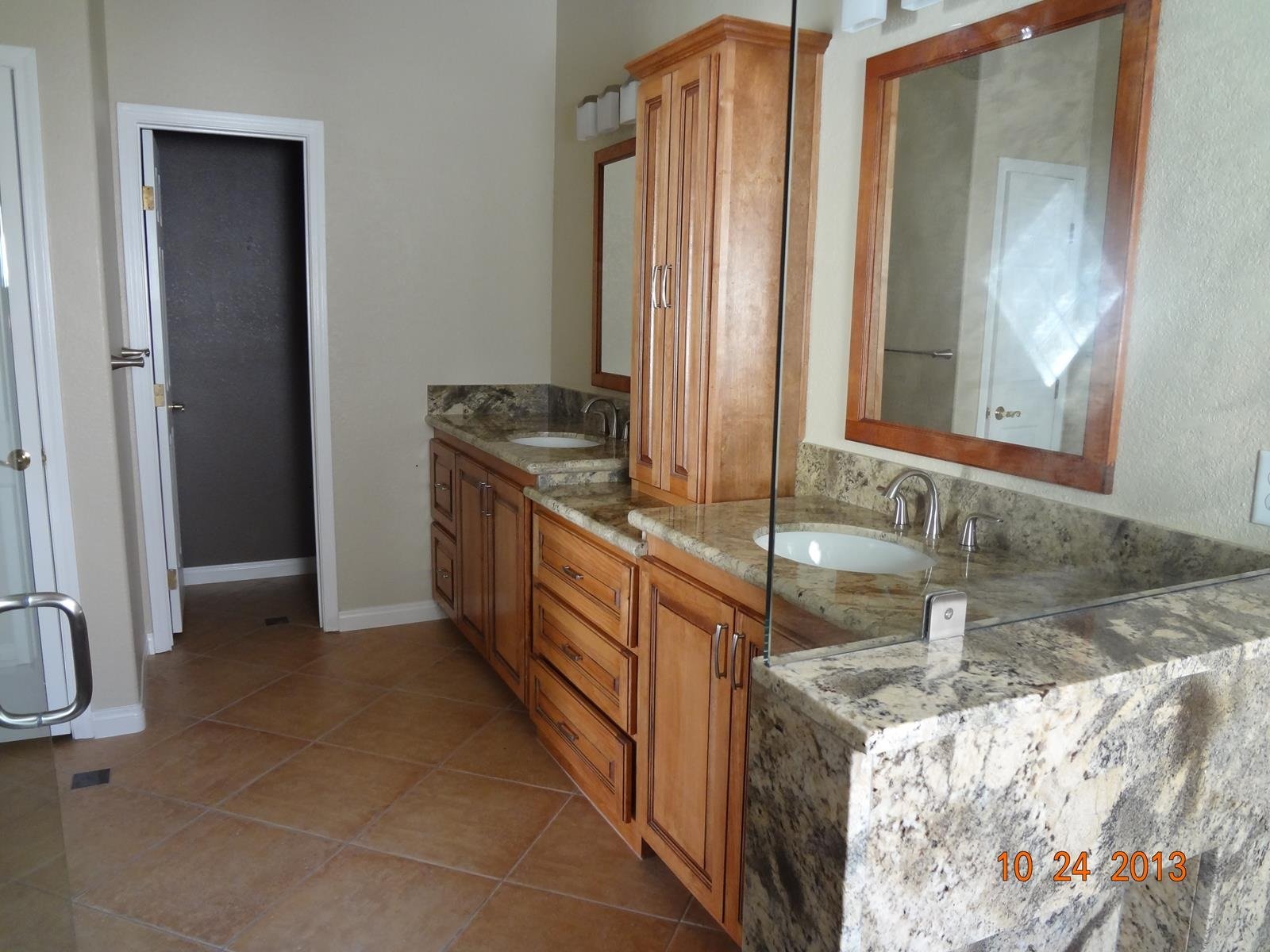 Custom bathroom vanity installation with dual sinks and stone countertop finish