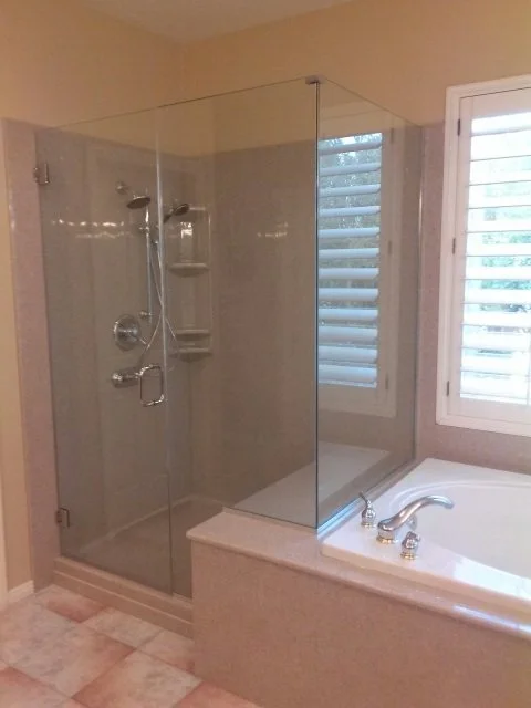 Frameless glass shower enclosure with soaking tub and tile surround bathroom remodel