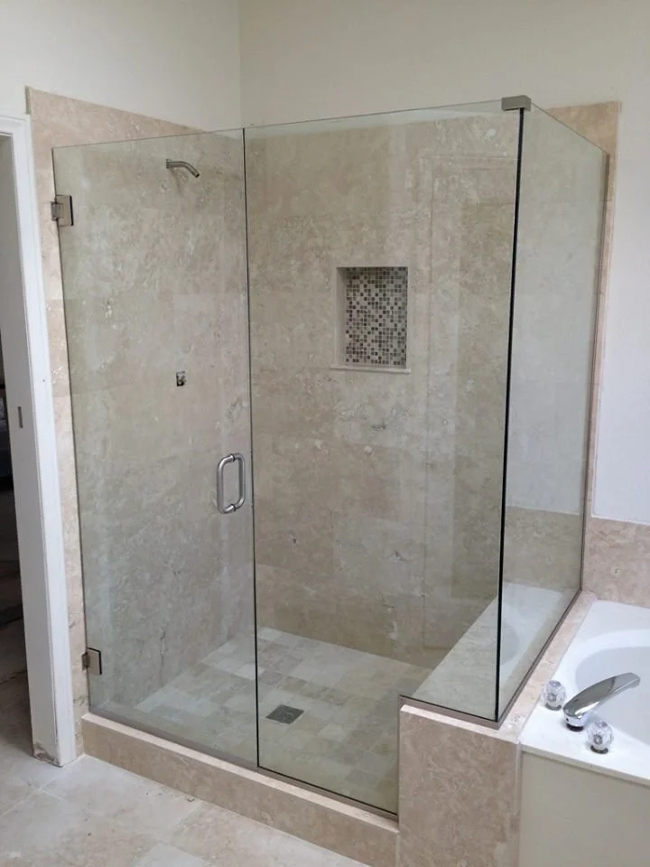 Walk-in shower remodel with frameless glass door and tile niche shelving