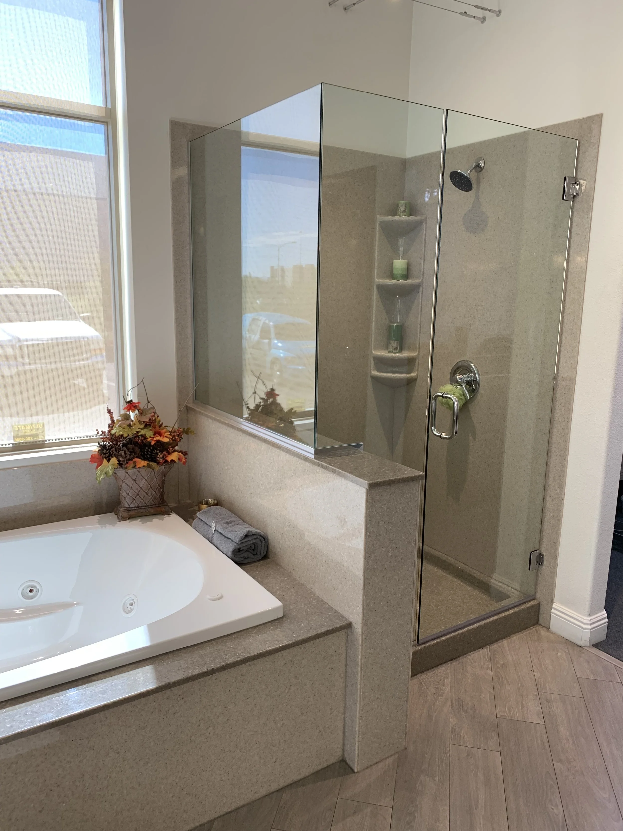 Bathtub with sliding glass shower doors, textured wall surround, and chrome hardware in a residential bathroom remodel.