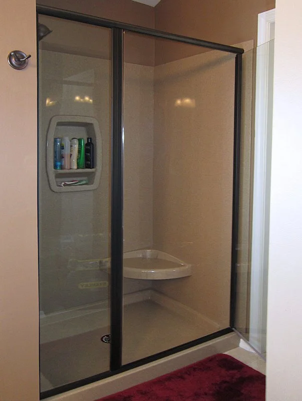 Luxury bathroom remodel with freestanding soaking tub, frameless glass shower enclosure, and polished tile flooring.