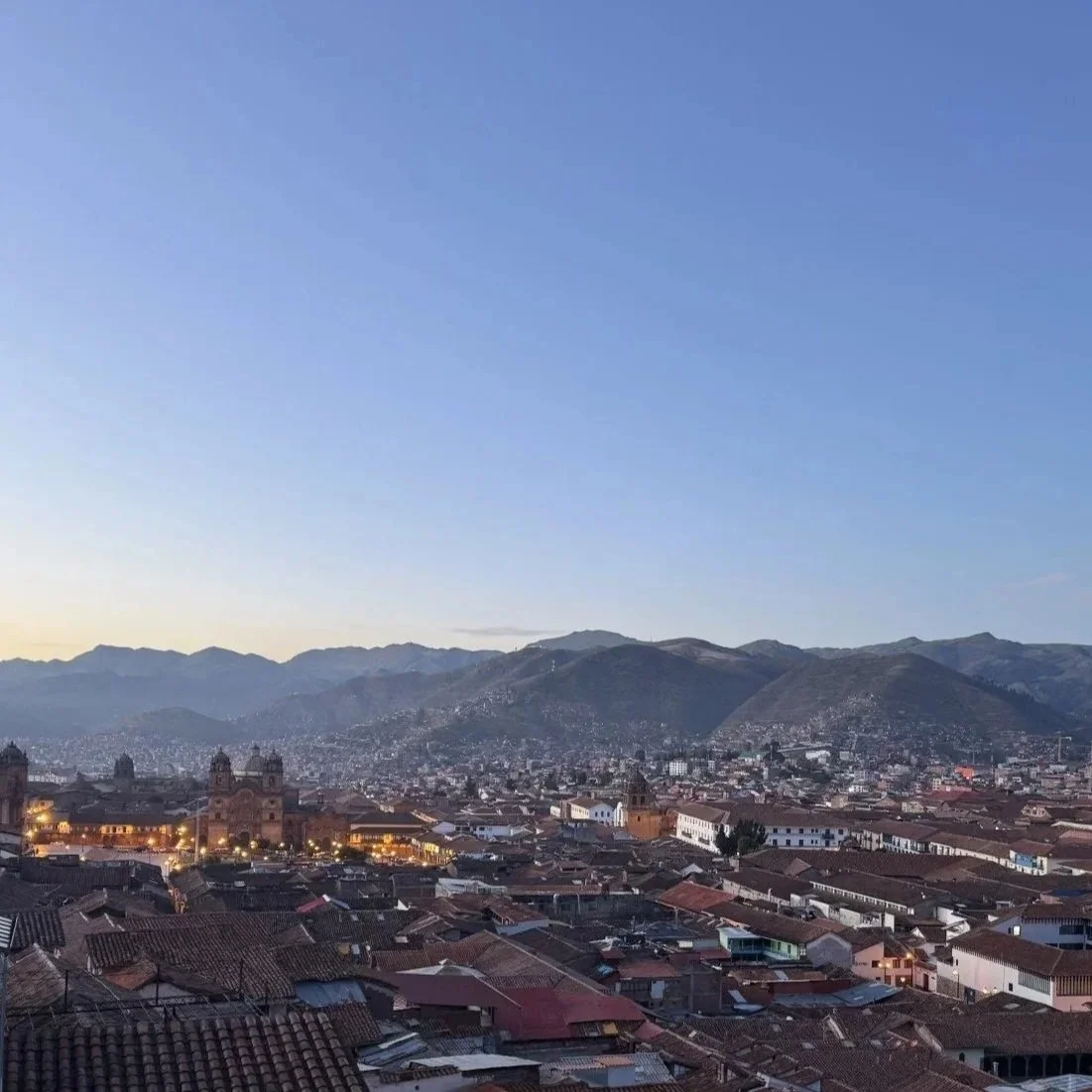 Early morning view over Cusco’s red-tiled rooftops with the Plaza de Armas and mountains in the distance