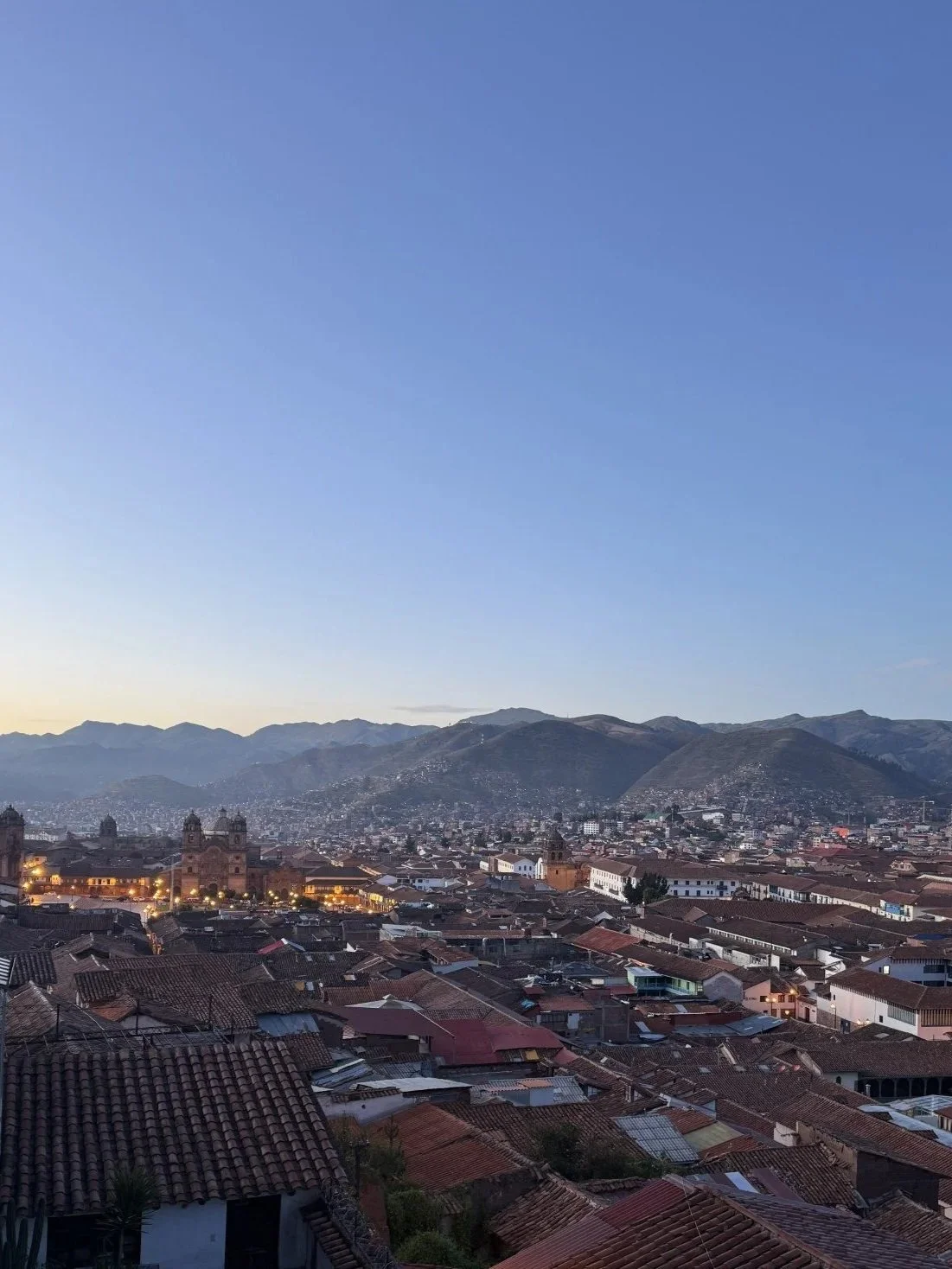 Early morning view over Cusco’s red-tiled rooftops with the Plaza de Armas and mountains in the distance