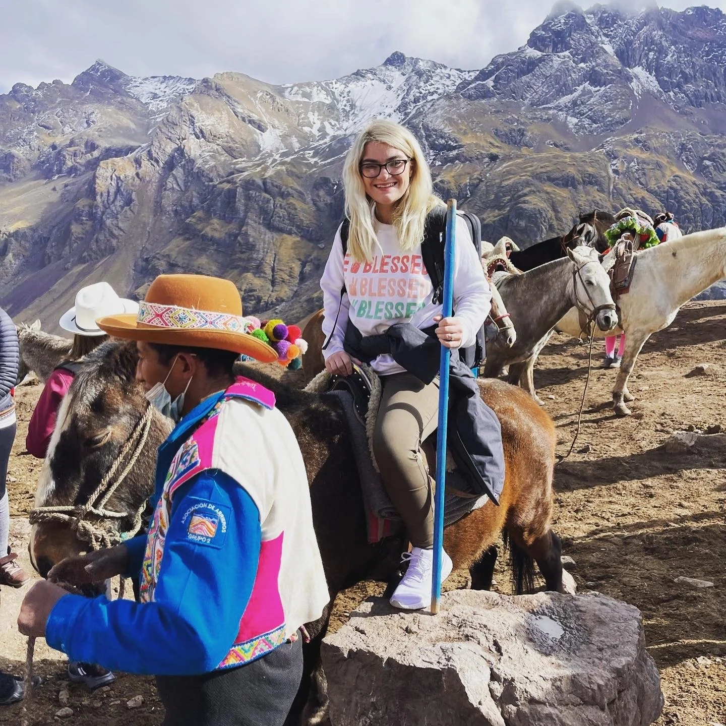 Woman riding a horse with a local guide at Vinicunca (Rainbow Mountain) in the Peruvian Andes
