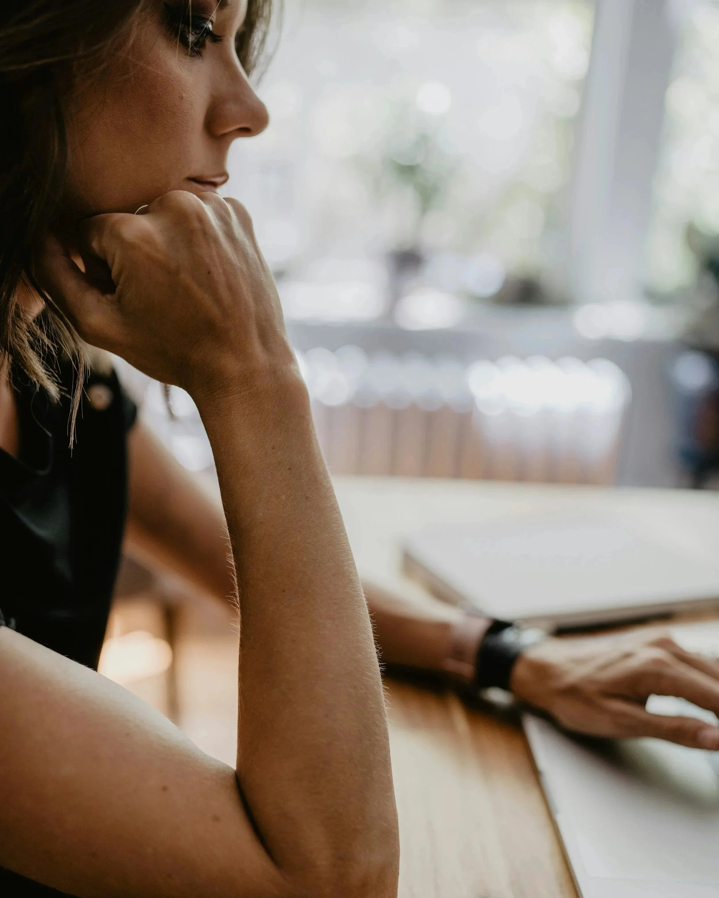 Woman pausing in a moment of quiet fatigue, reflecting on symptoms that don't have an explanation
