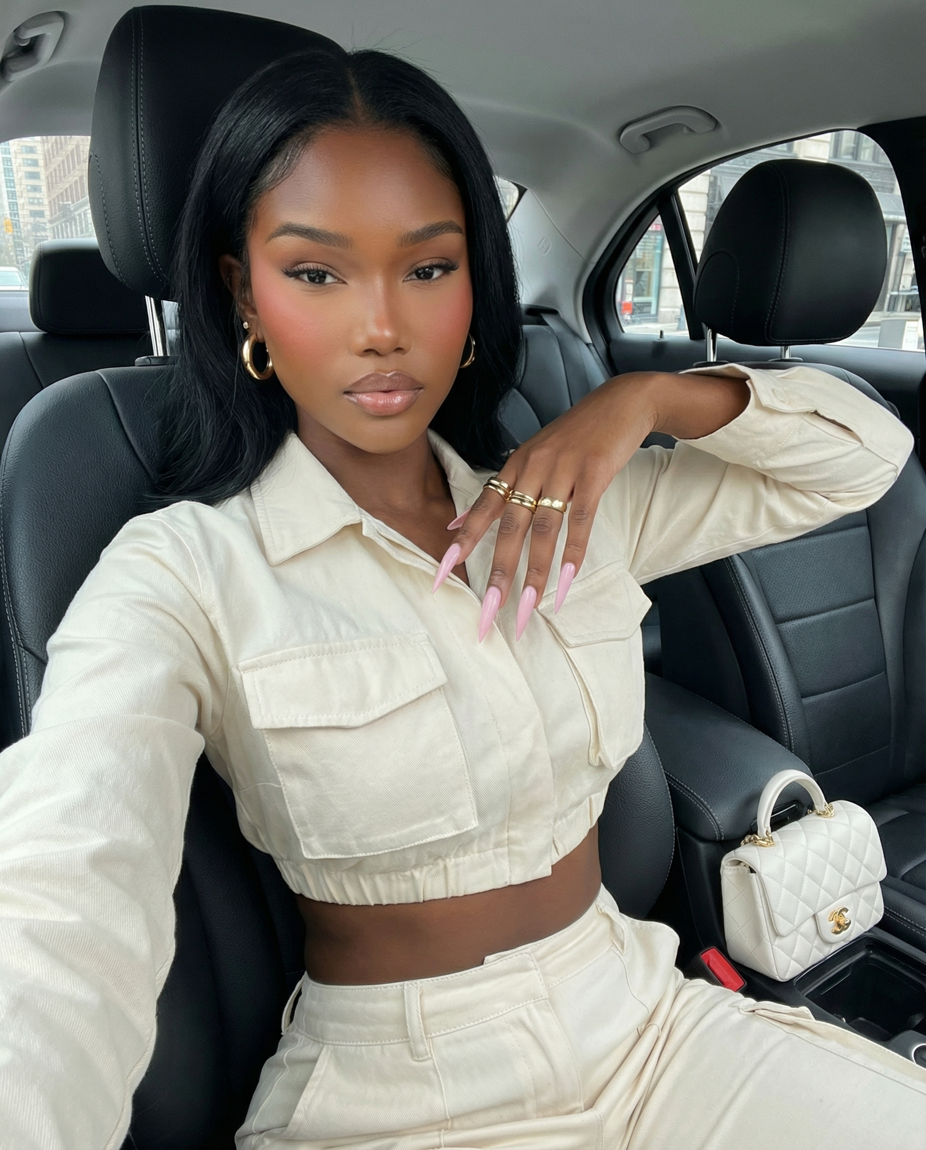 AI-generated influencer avatar sitting in a car wearing a beige outfit, created using a copy-paste AI avatar prompt with consistent lighting and facial detail.