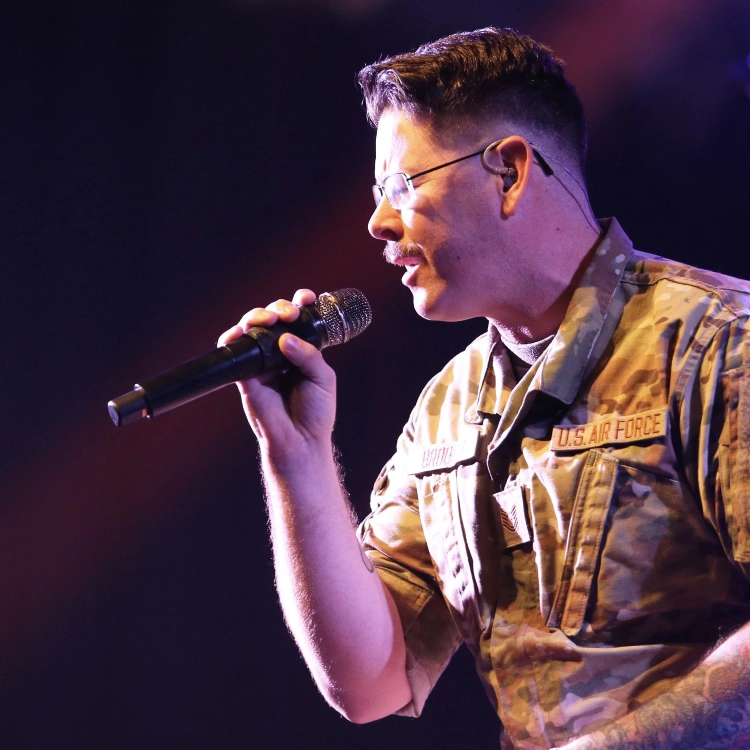 A man in military uniform singing into a microphone.