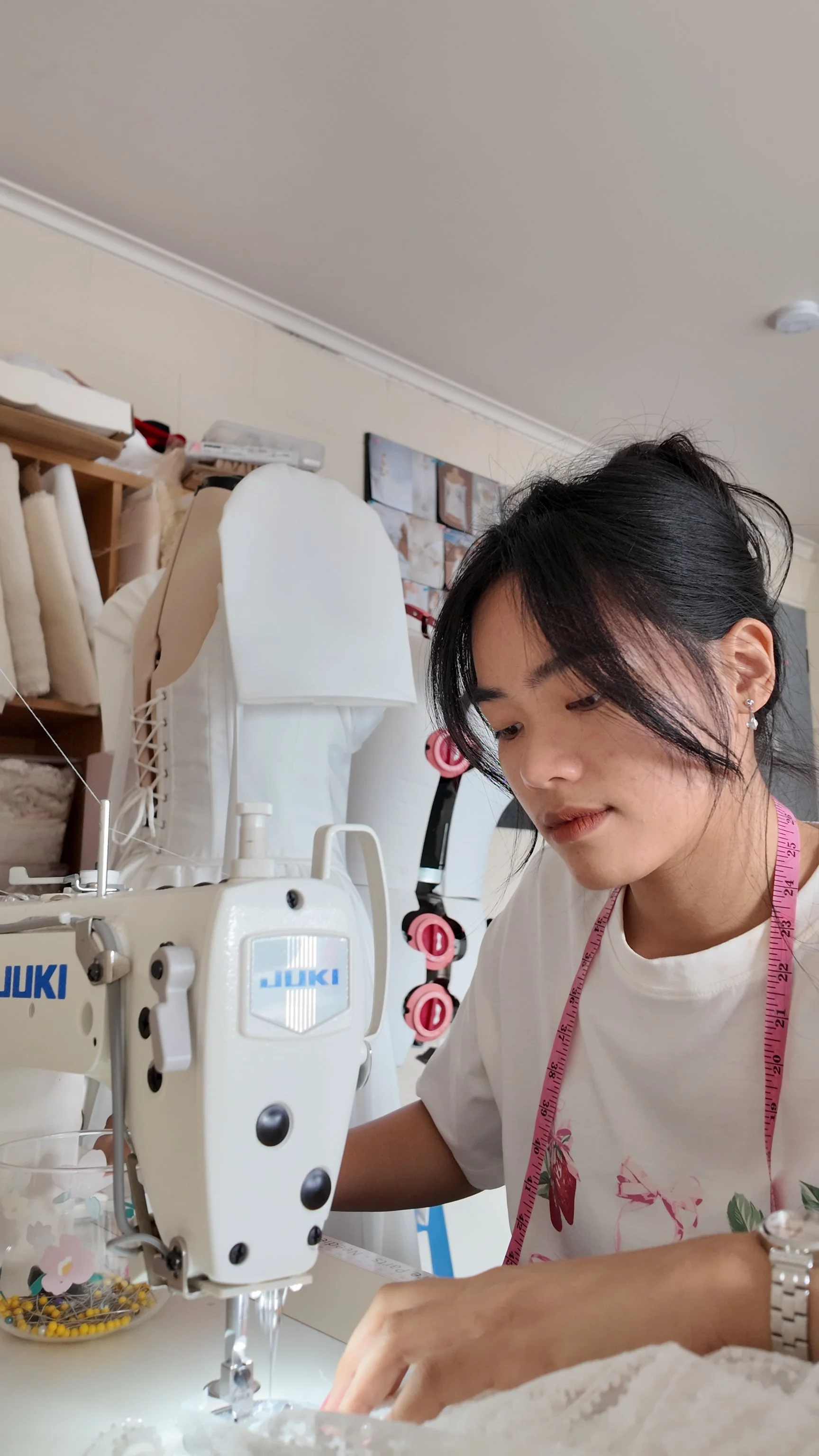 Young woman sewing with a Juki industrial sewing machine in a craft room.