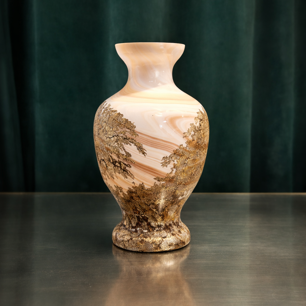 A decorative ceramic vase with a marbled pattern and gold accents, sitting on a dark surface with a dark green curtain in the background.