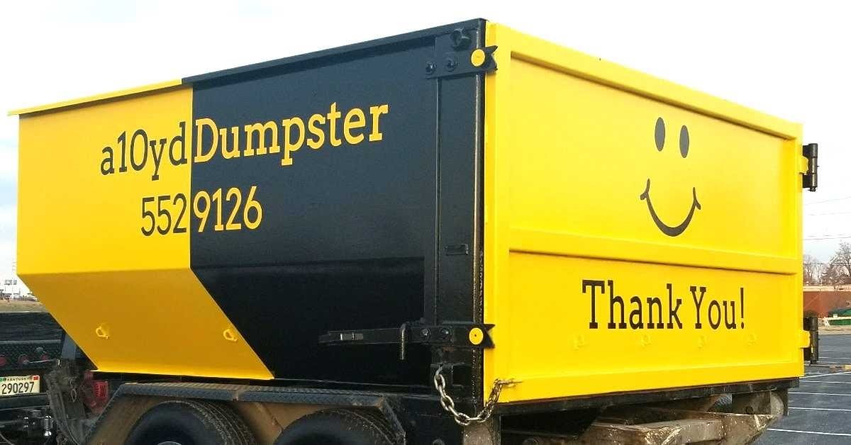 A yellow and black truck with the text "a10ydumpster" and a phone number. The truck has a smiley face and a "Thank You!" message on it.