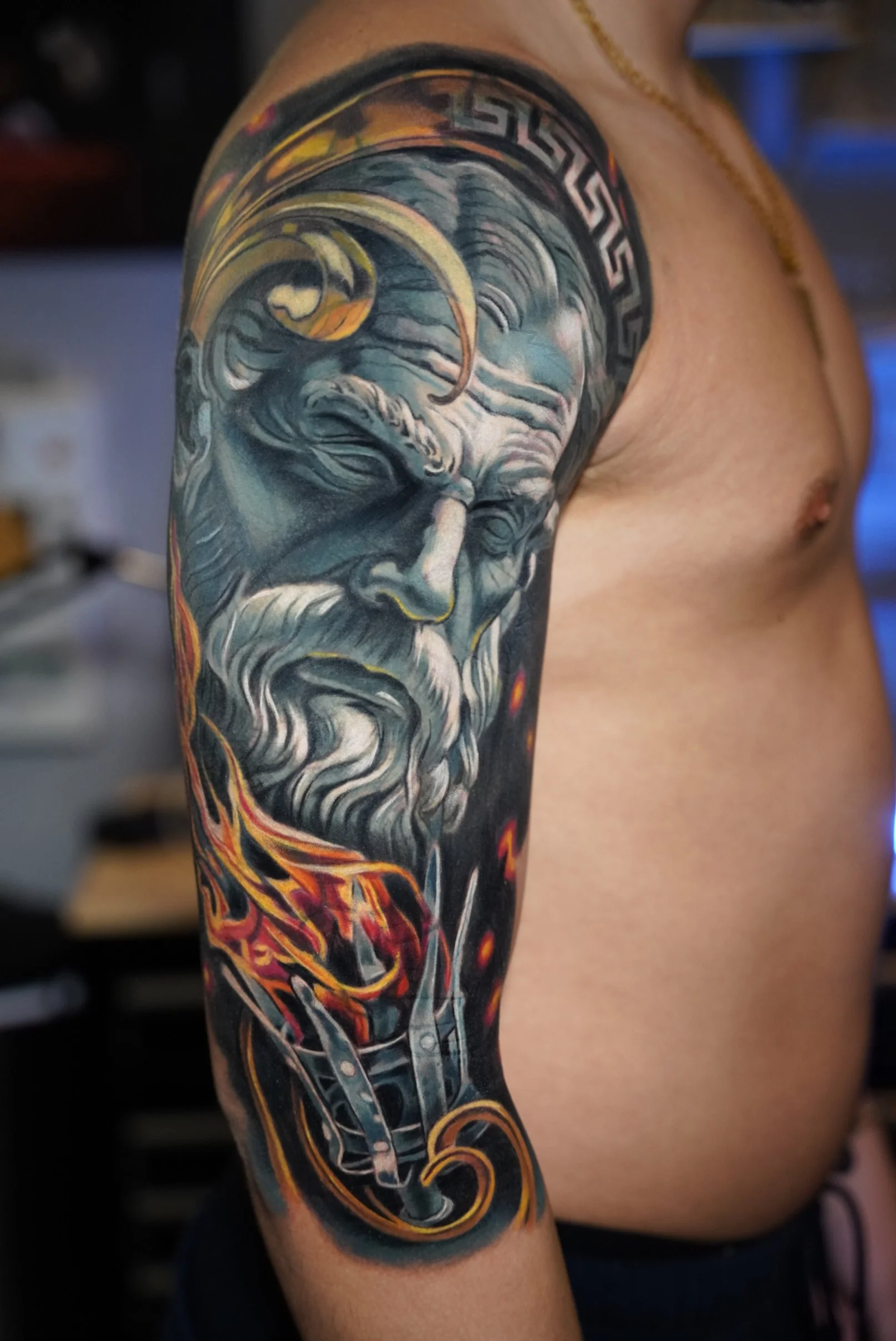 Classical sculpture-inspired realism tattoo with dramatic lighting and warm accent tones. This piece blends fine detail, texture, and movement as part of a cohesive full sleeve composition.