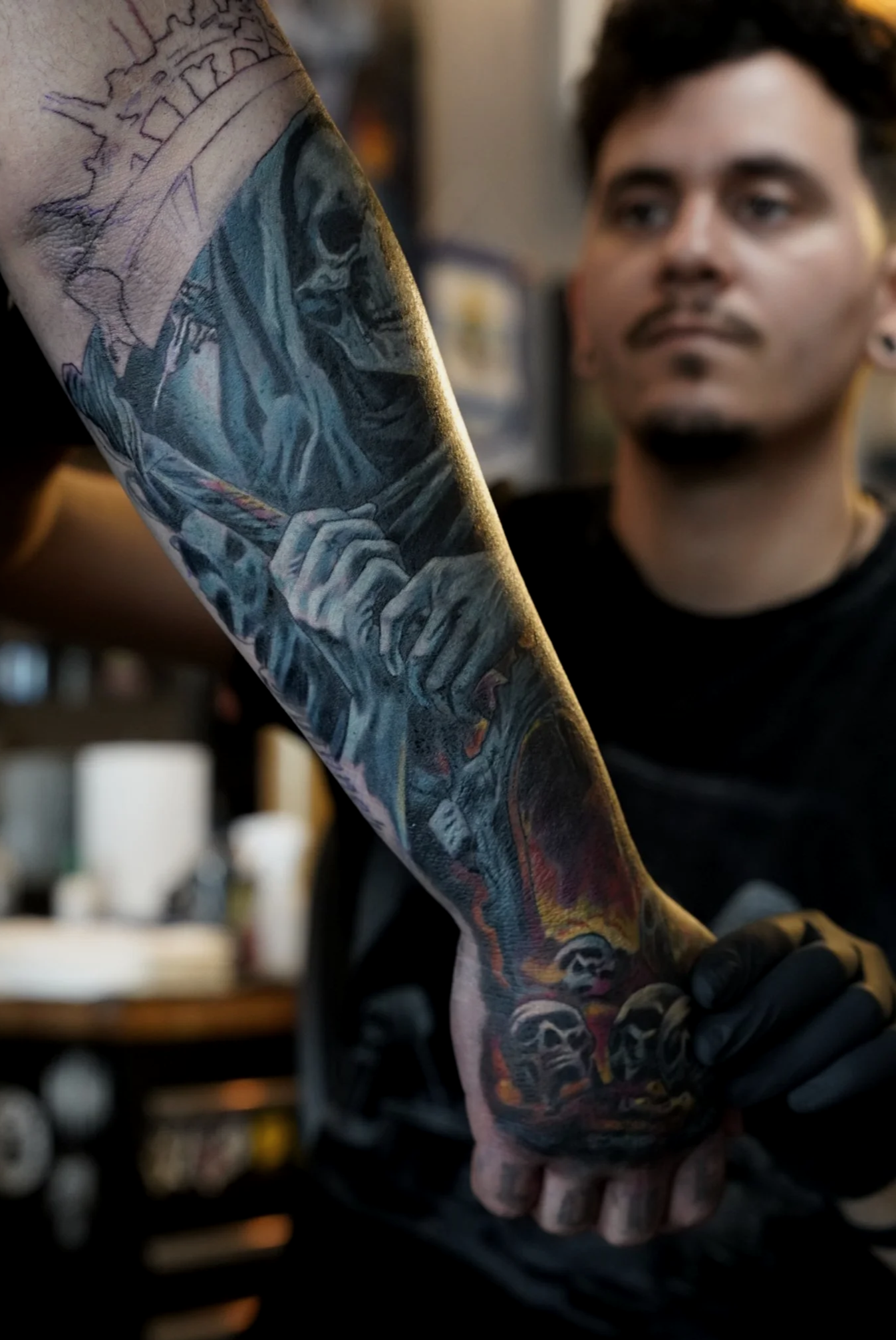 Cover up tattoo in progress on forearm and hand featuring dark reaper and skull design