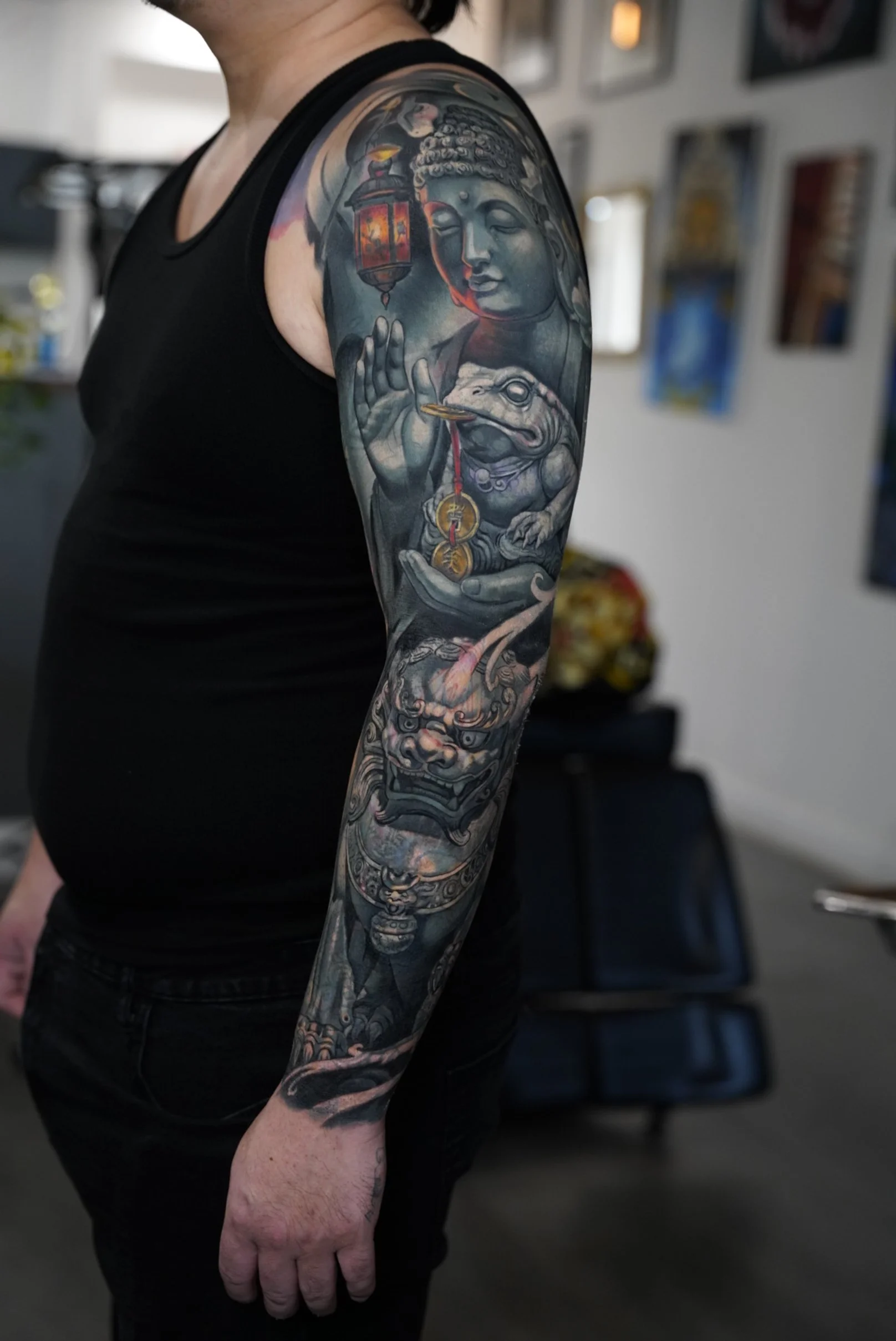 Fully healed sleeve tattoo combining Buddha imagery and traditional elements, executed in detailed realism with smooth shading, long-term readability, and cohesive flow.

