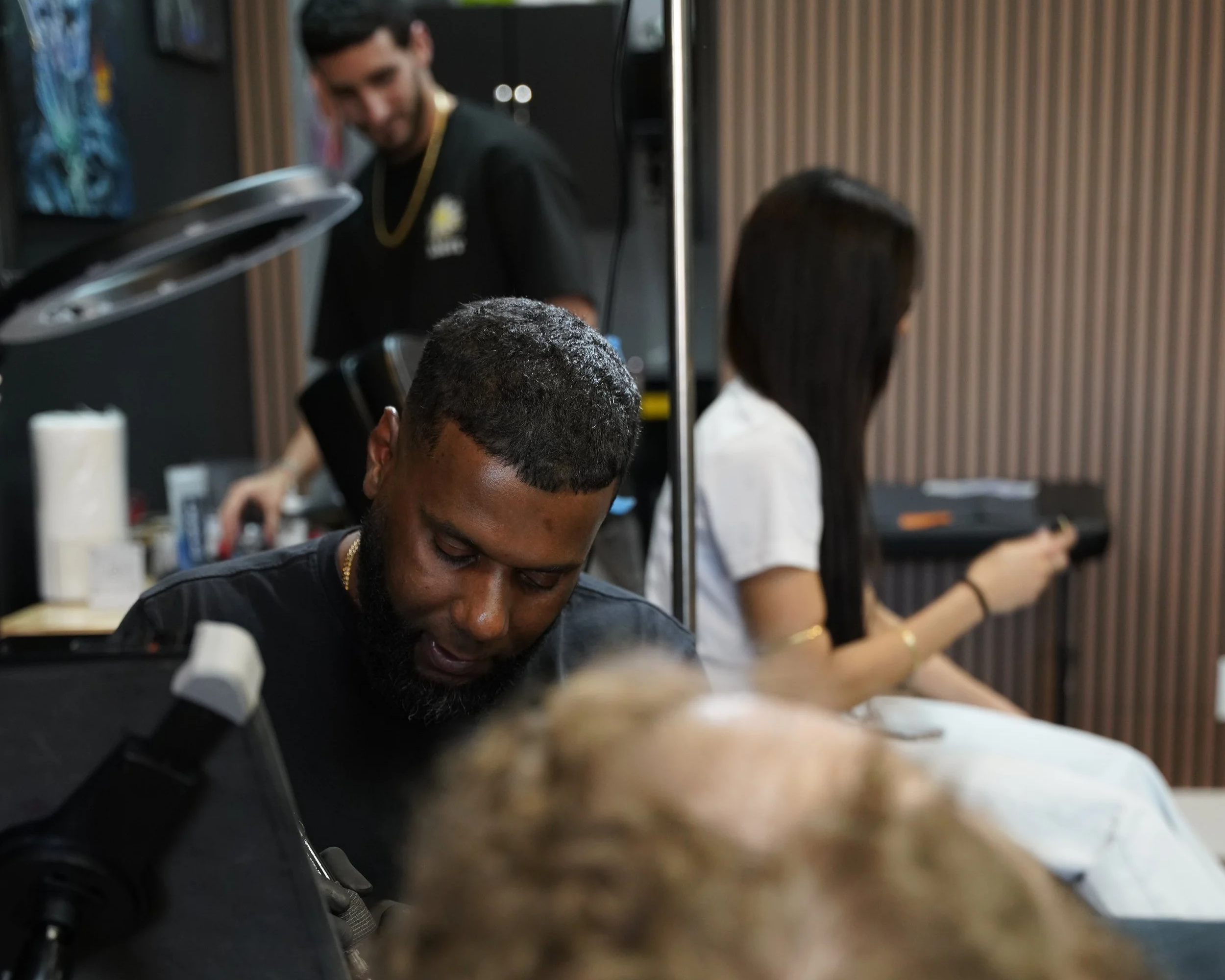 Alexis Torres tattooing a client at Black Nova Tattoo Collective in Miami, showcasing precision, professionalism, and the collaborative atmosphere of the studio.