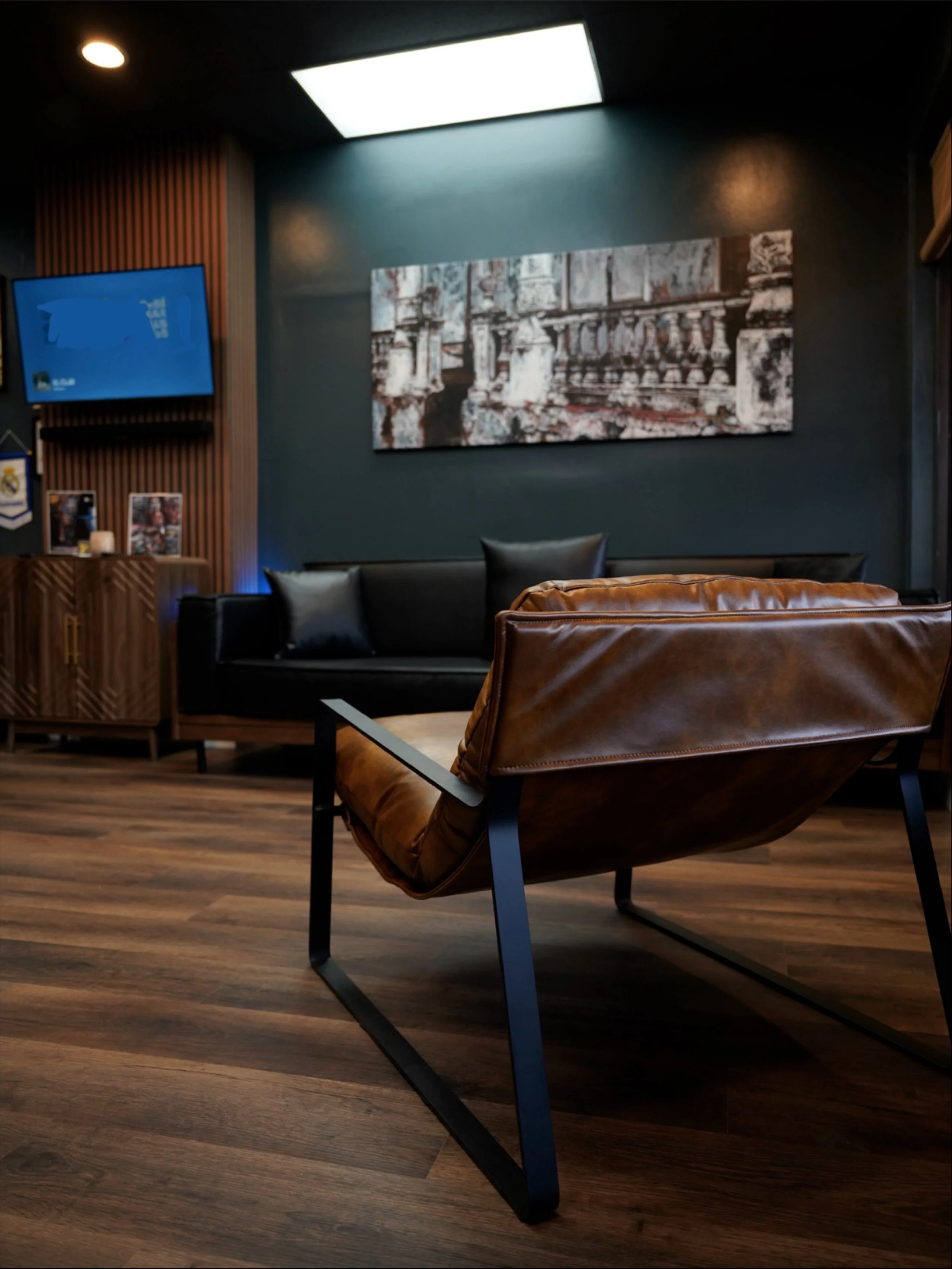 Modern waiting area at Black Nova Tattoo Collective in Miami featuring premium leather seating, contemporary artwork, and a welcoming atmosphere for tattoo consultations.