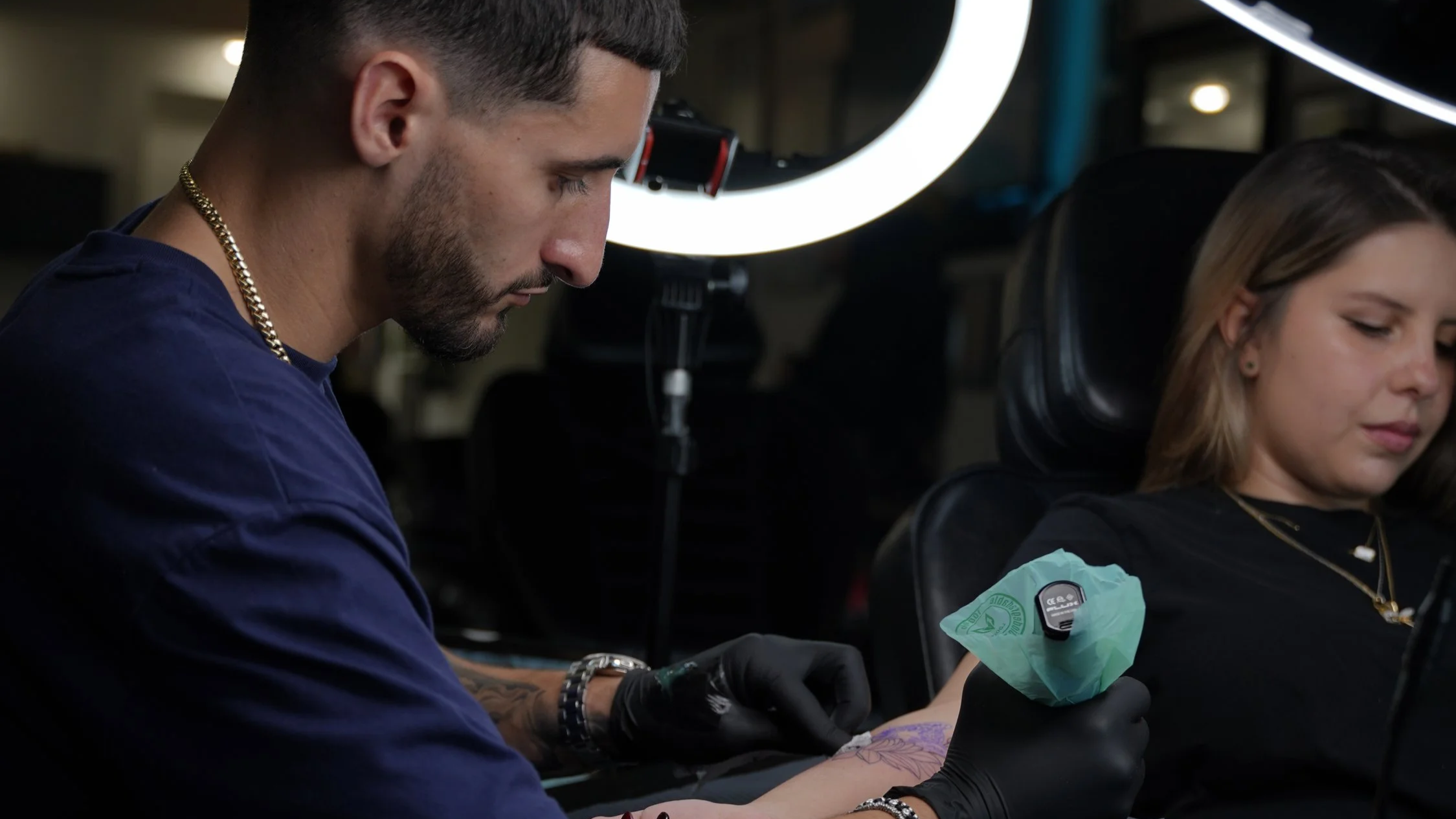 Sandy, fine line tattoo artist, creating a custom tattoo for a client at Black Nova Tattoo Collective in Miami using professional tattoo equipment.