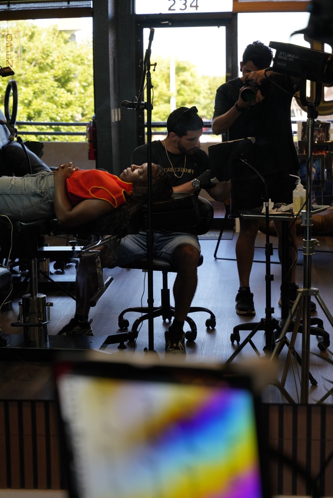 Tattoo artist working on a client while a photographer captures the process at Black Nova Tattoo Collective in Miami, highlighting the studio’s professional tattoo experience and creative environment.
