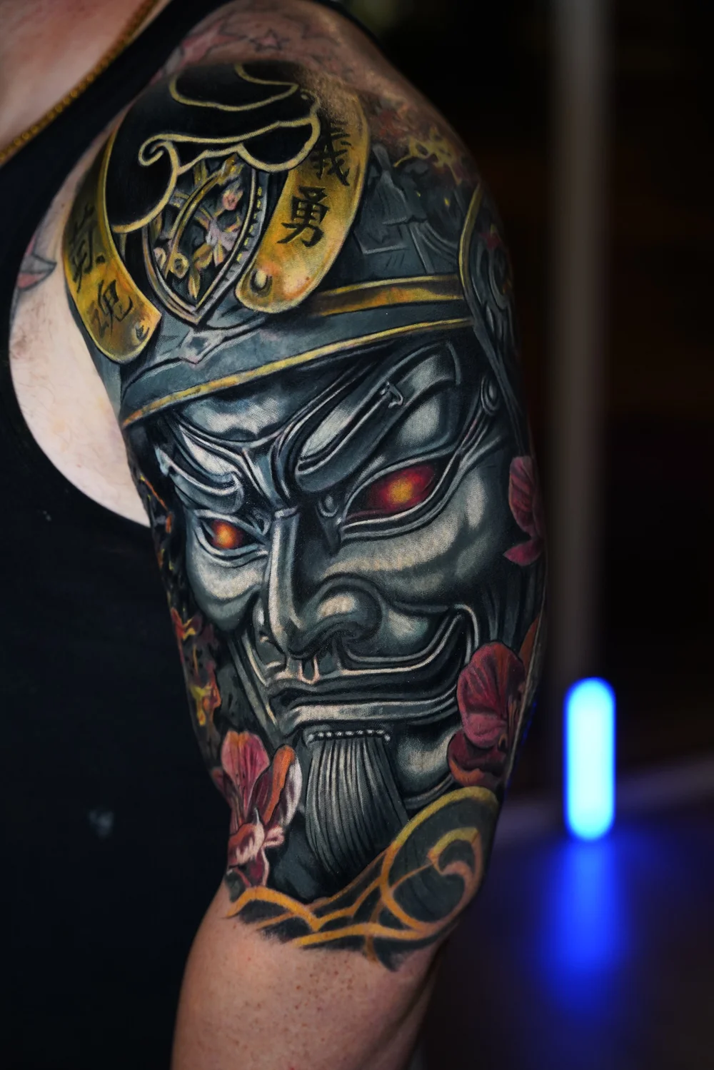 Color realism Japanese Hannya mask sleeve tattoo featuring glowing eyes, gold accents, and floral details, created by Yorlandi Fabregas at Black Nova Tattoo Collective in Miami.