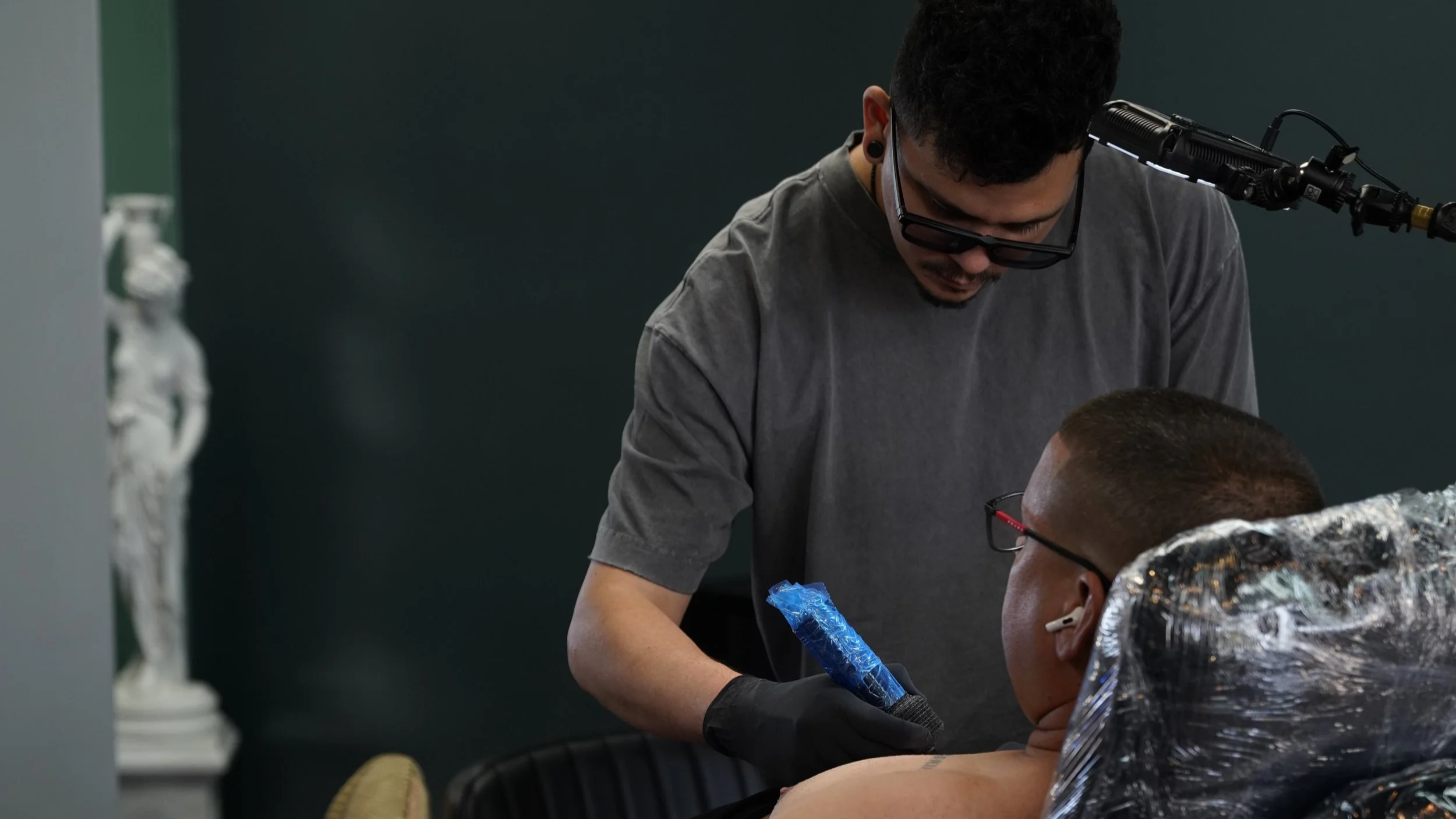 Yorlandi Fabregas consulting with a client before a custom tattoo session at Black Nova Tattoo Collective in Miami, discussing the design and placement for a personalized tattoo.