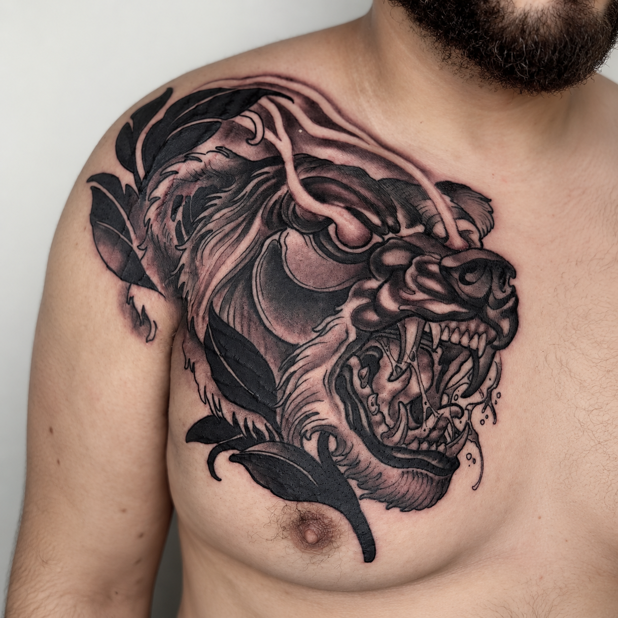 Black and grey roaring panther tattoo across the chest and shoulder by Adrian Aguirre.
