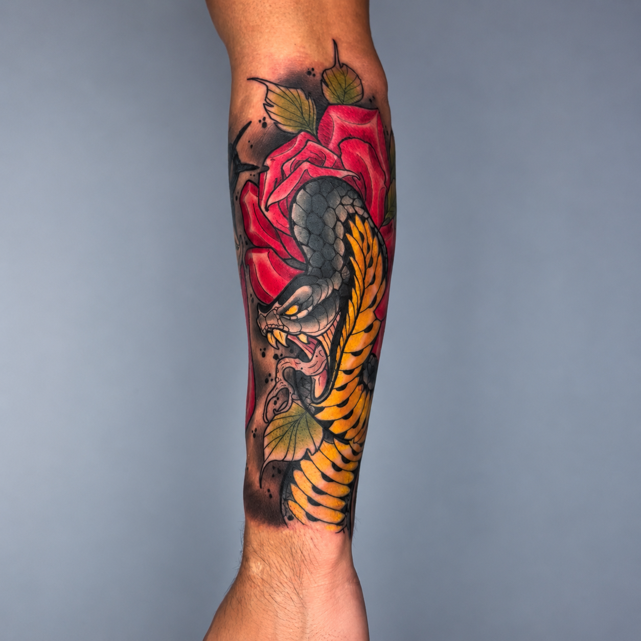 Color snake and red rose tattoo by Adrian Aguirre.