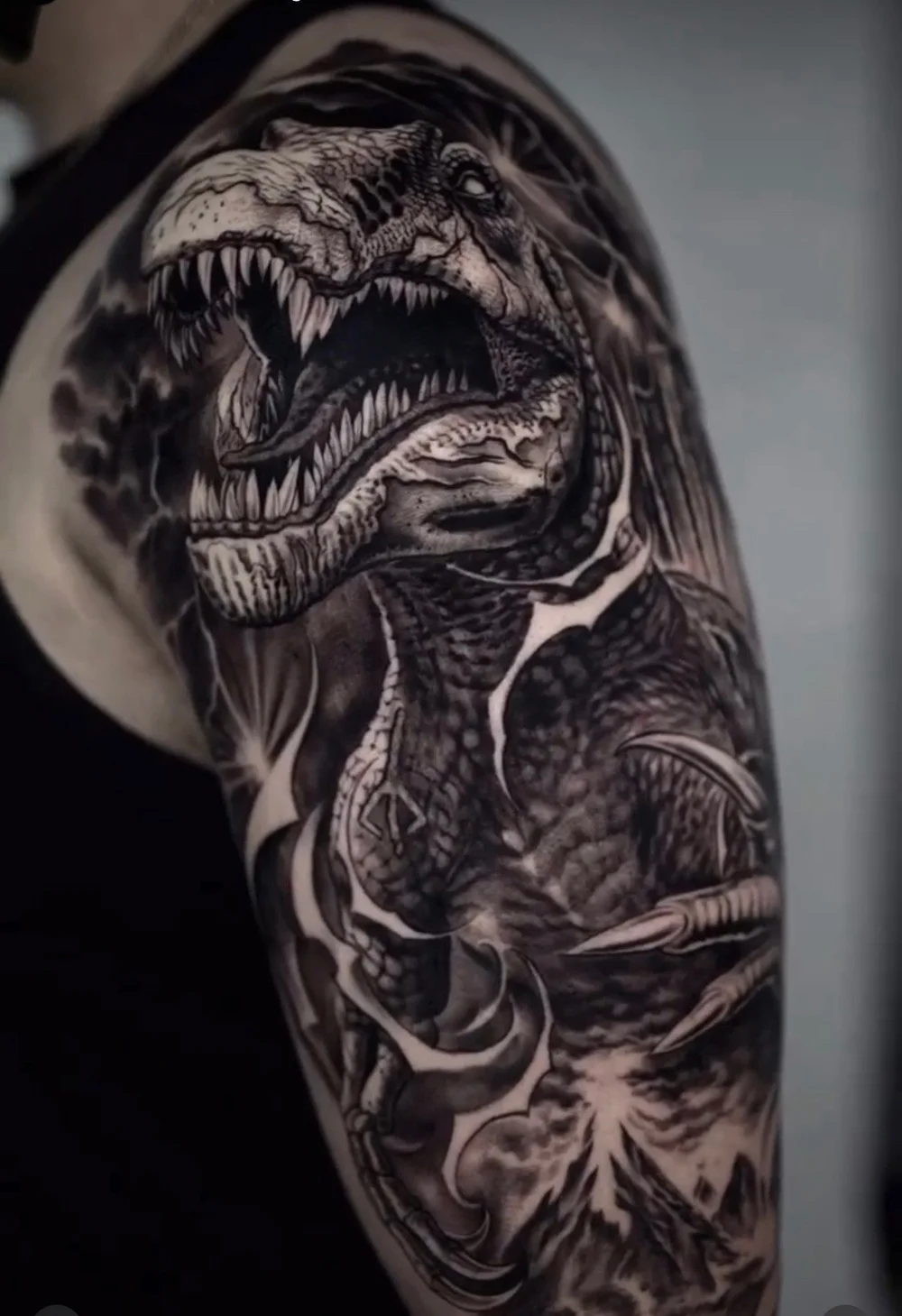 Black and grey realism T-Rex sleeve tattoo by Alexis Torres featuring a roaring Tyrannosaurus rex with dramatic shading at Black Nova Tattoo Collective in Miami.