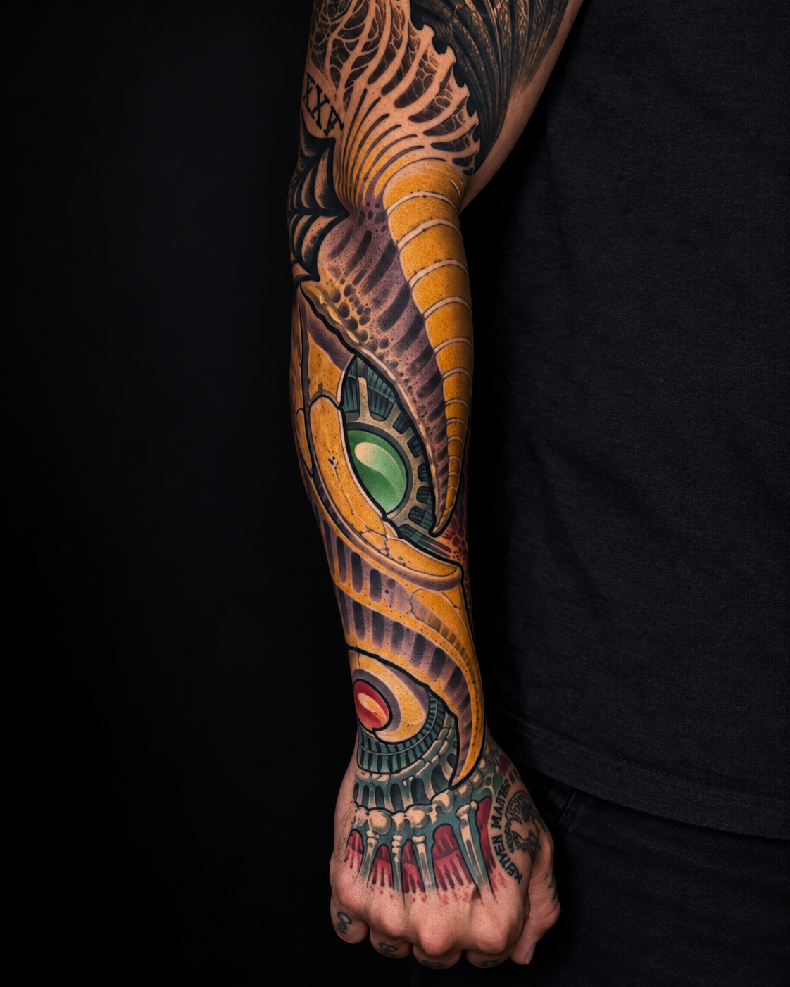 Ornamental forearm and hand tattoo with green eye details by Adrian Aguirre.