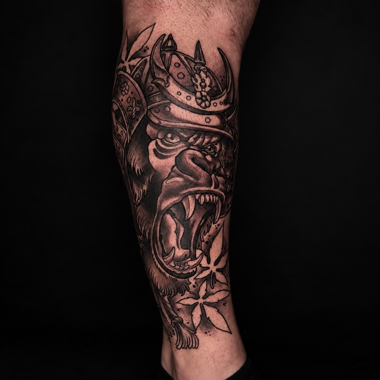 Black and grey samurai mask forearm tattoo by Adrian Aguirre.