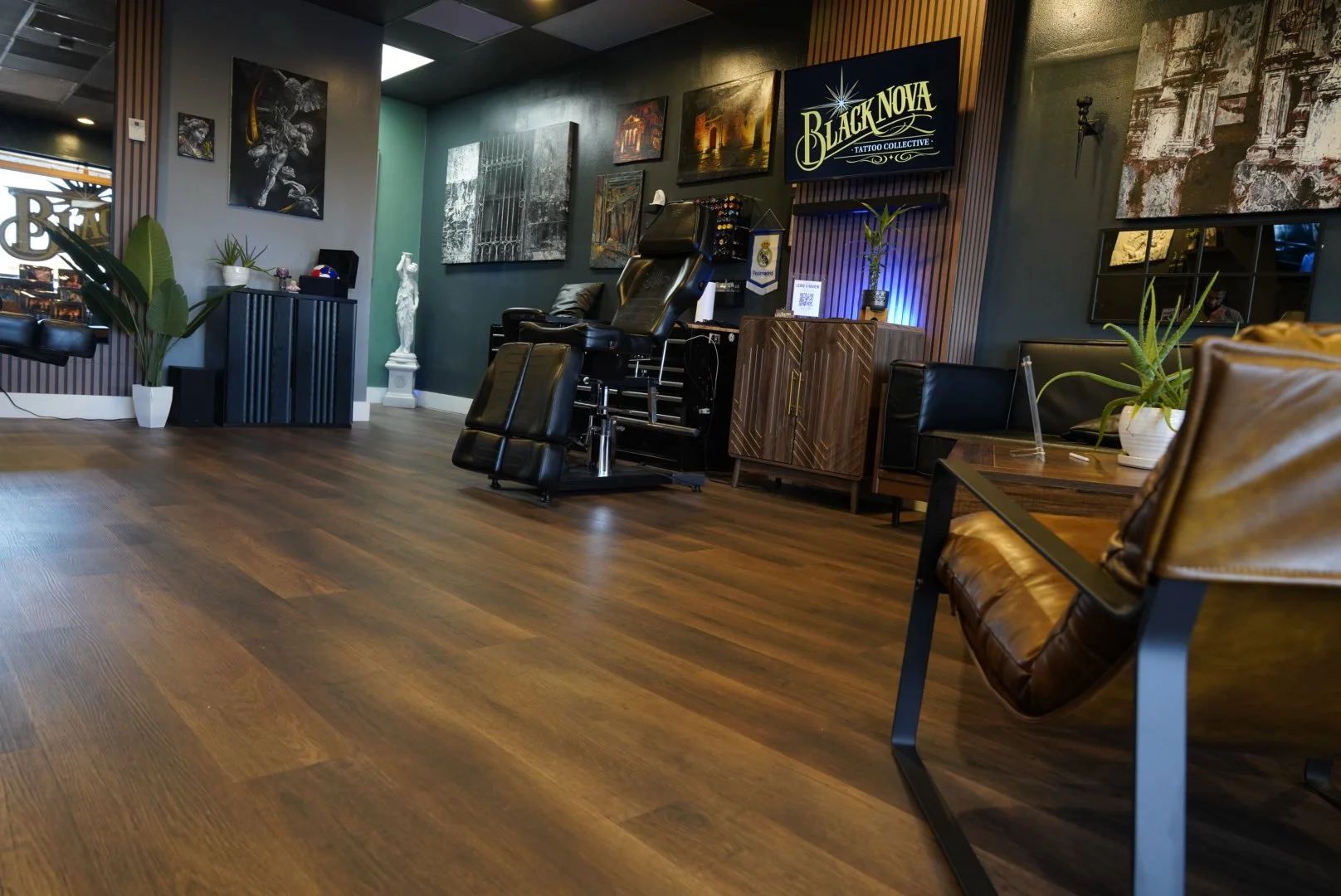 Interior of Black Nova Tattoo Collective in Miami, with tattoo stations, artwork and a client seating area.