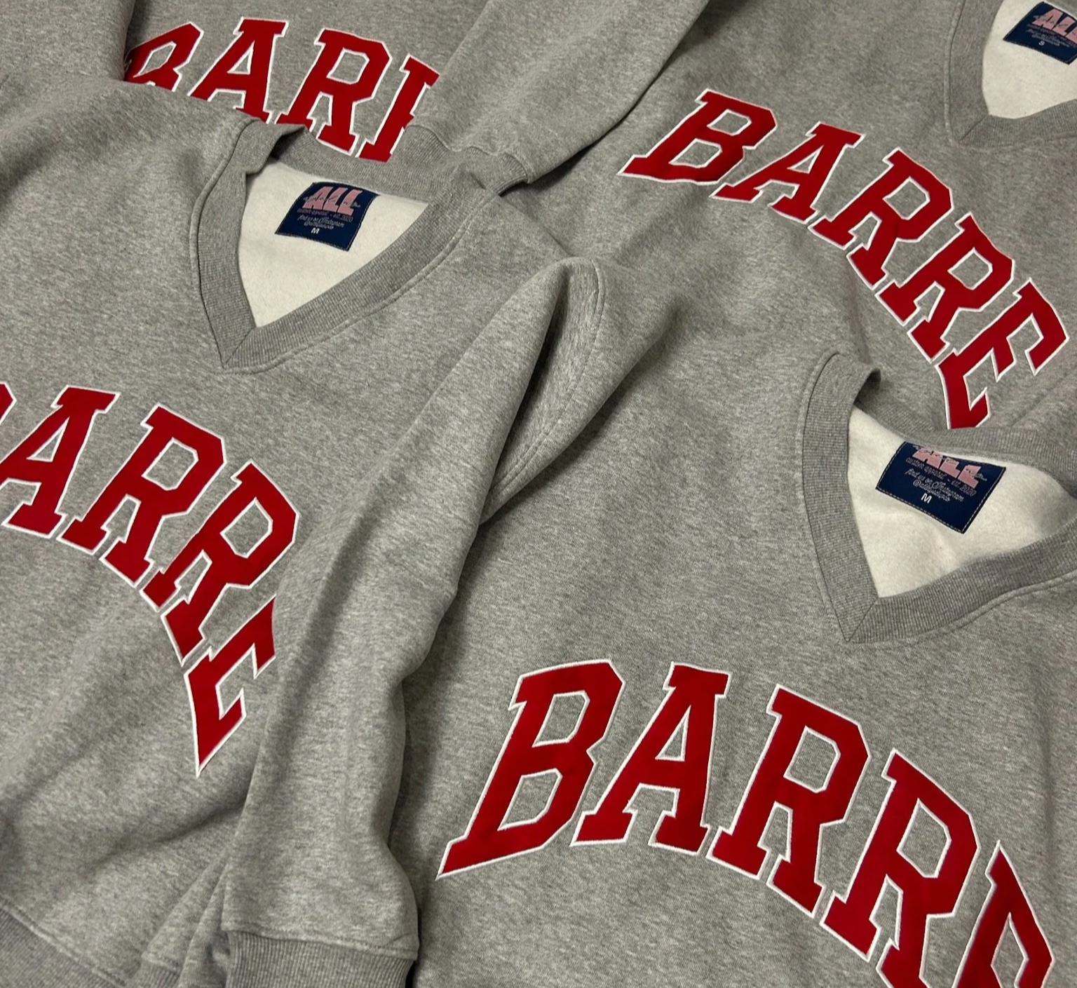 Two gray sweatshirts with red text reading 'BARKING BAD' laid flat.