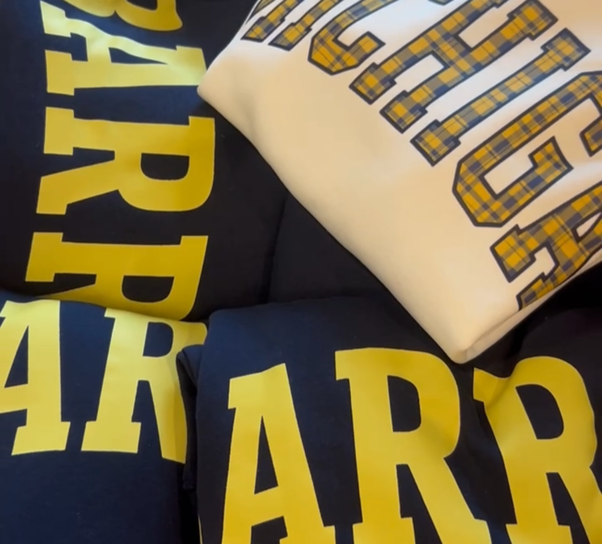 Various folded cloths with text and checkered patterns in yellow, black, and white colors.