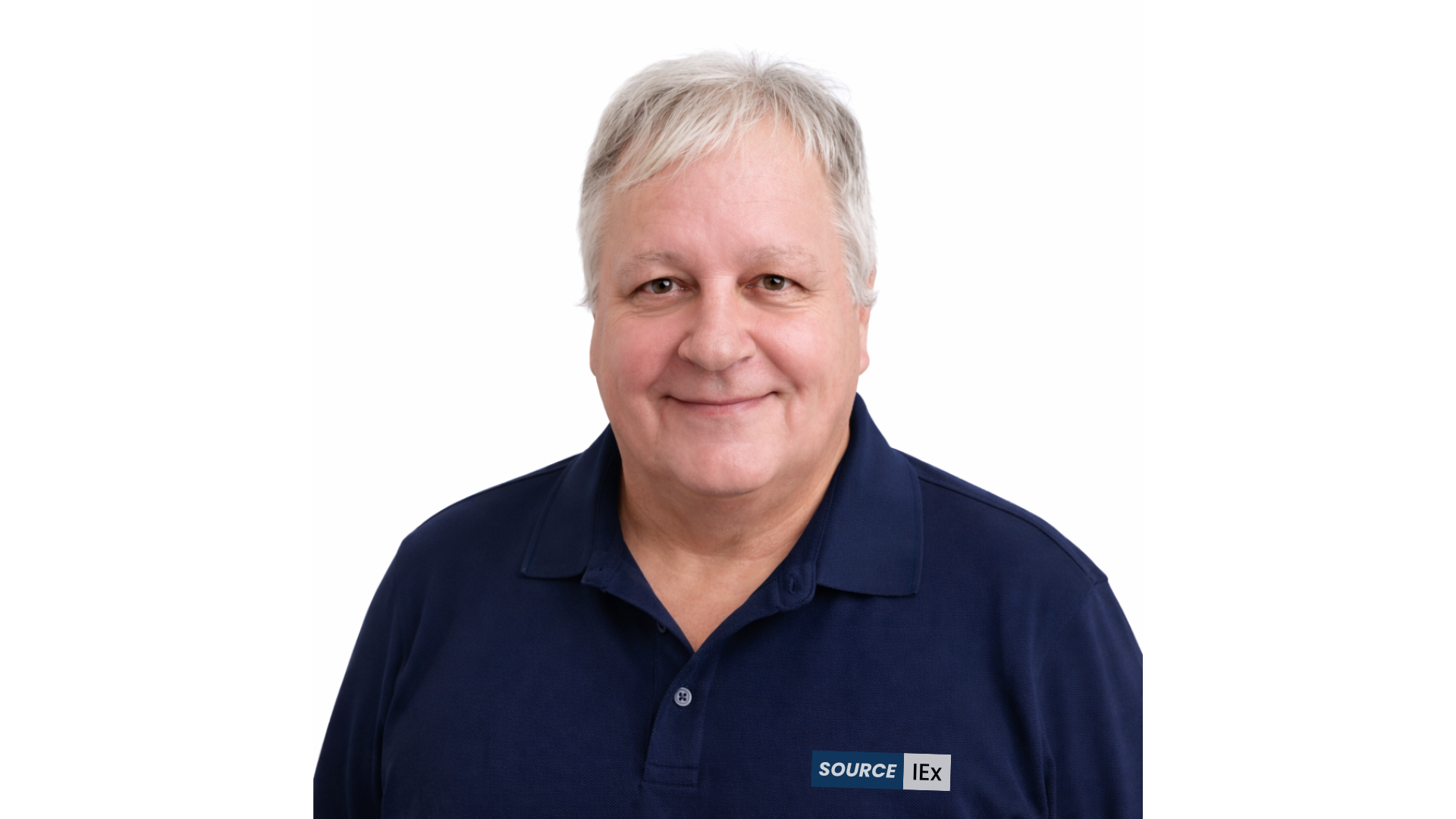 Headshot of a middle-aged man with gray hair smiling, wearing a navy blue polo shirt, against a white background.
