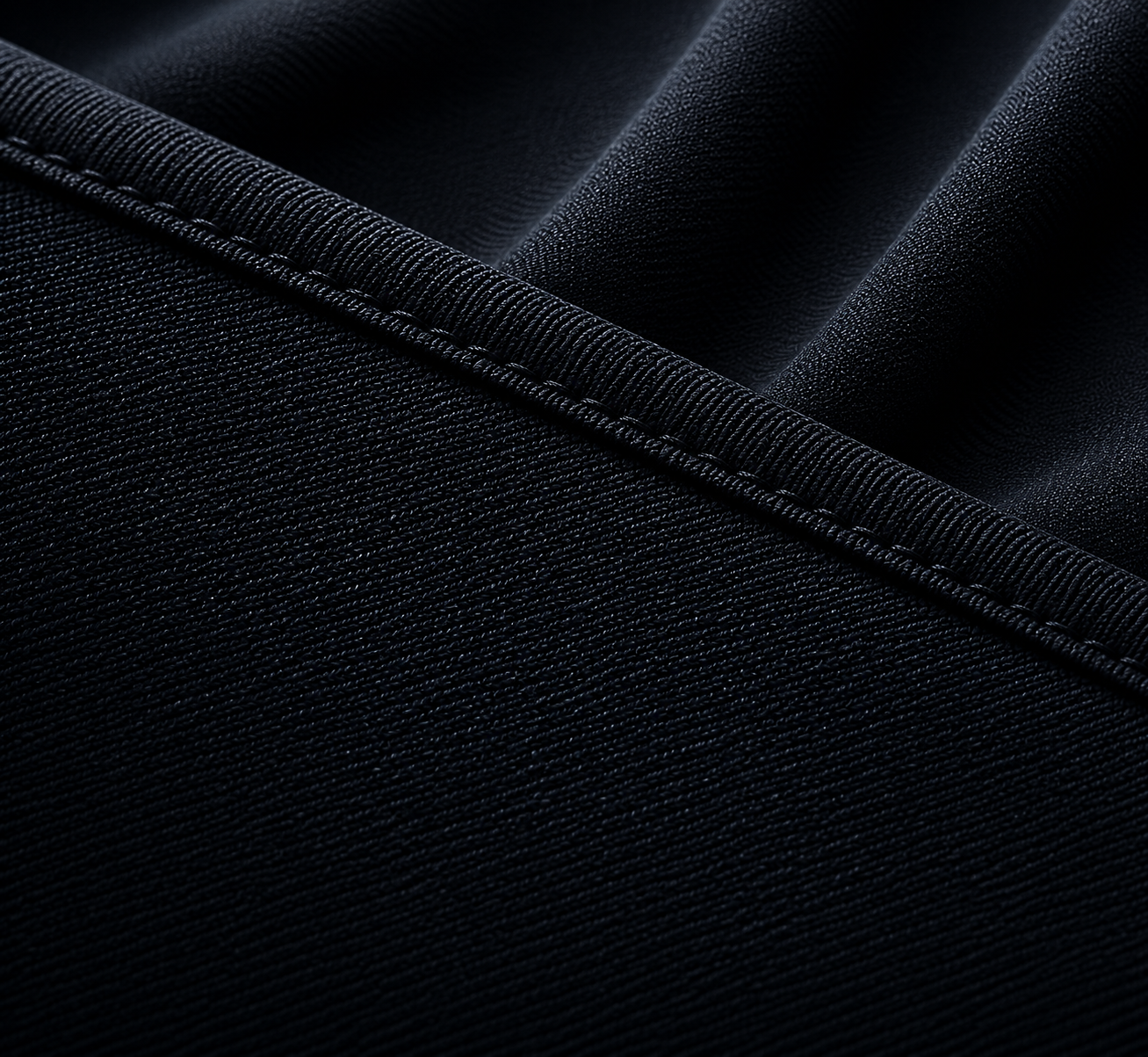 Close-up of black fabric with detailed stitching and texture.