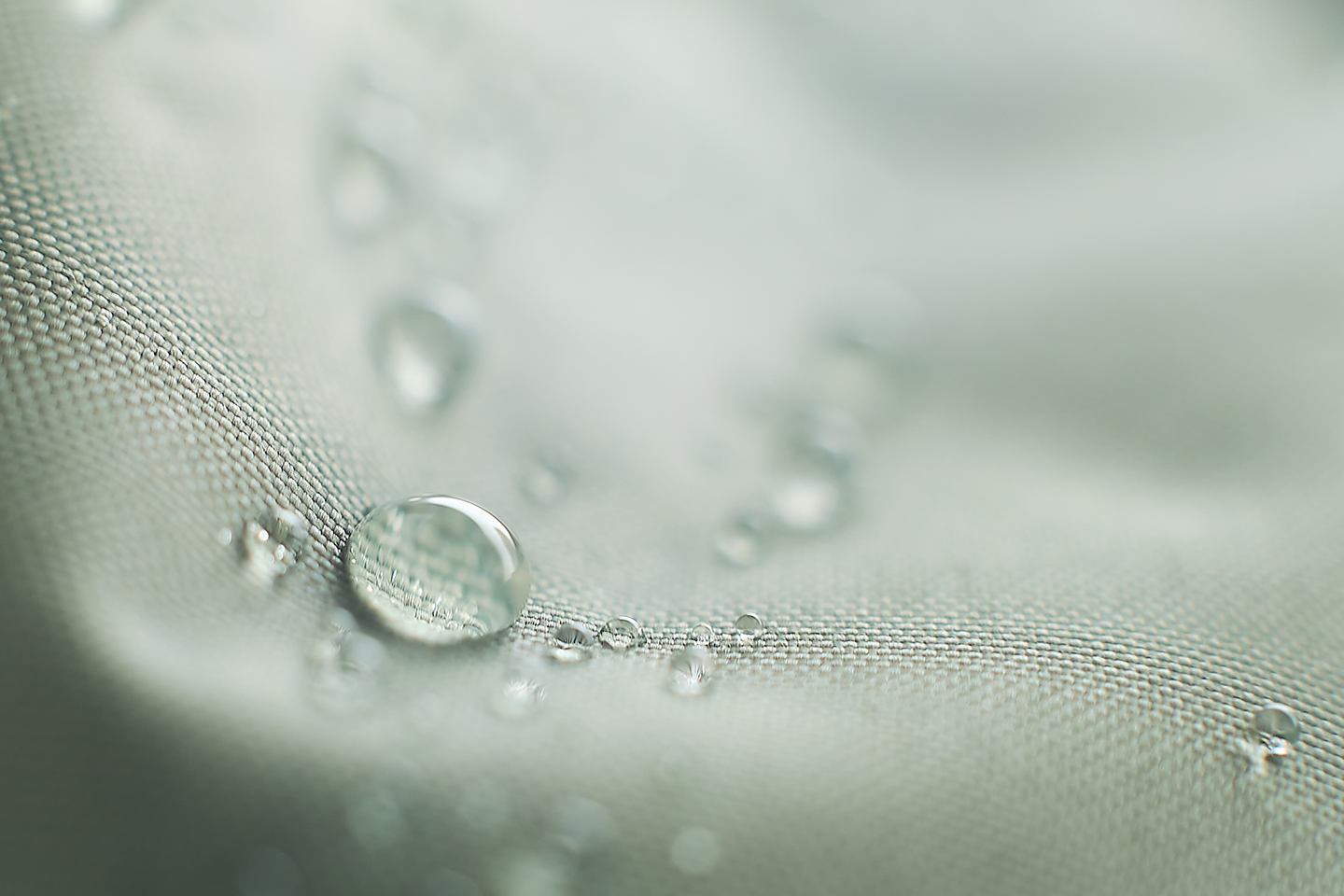 Close-up of water droplets on a textured fabric surface.