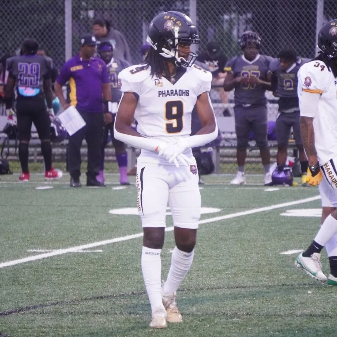 American football player wearing a white and black uniform with the number 9, standing on the field during a game.