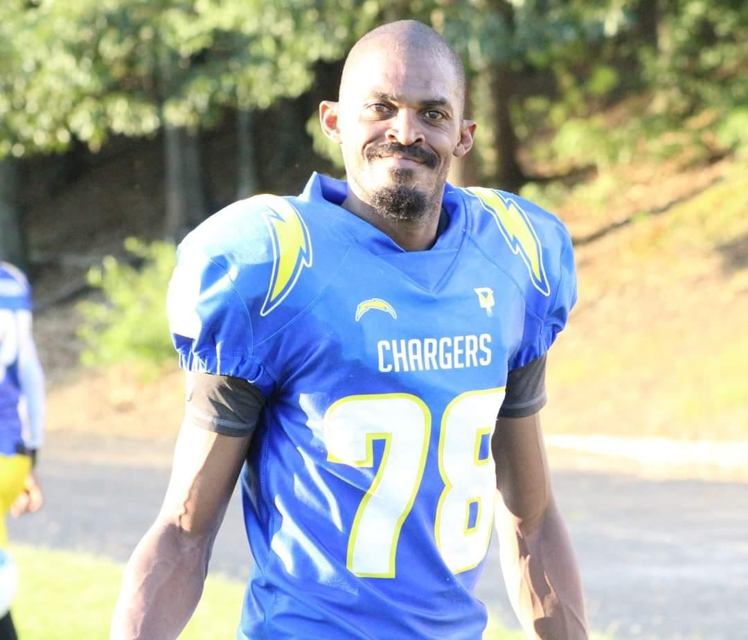Football player in a blue Chargers jersey, number 28, standing outdoors.