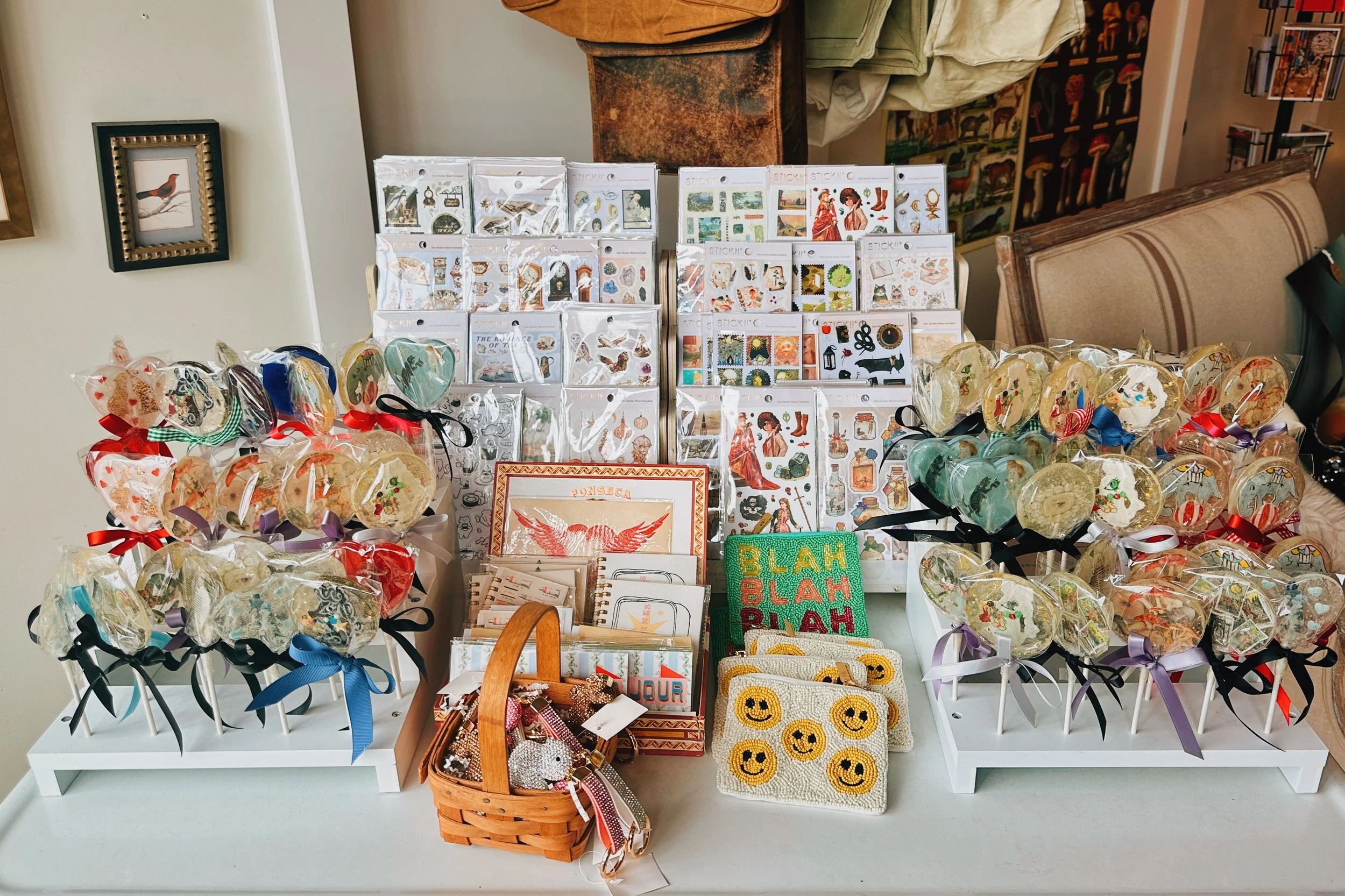 Display of assorted decorative items, including stickers, cookies, and small accessories, on a white table.