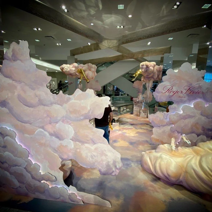 Display with pink and white clouds and gold accents inside a modern building.