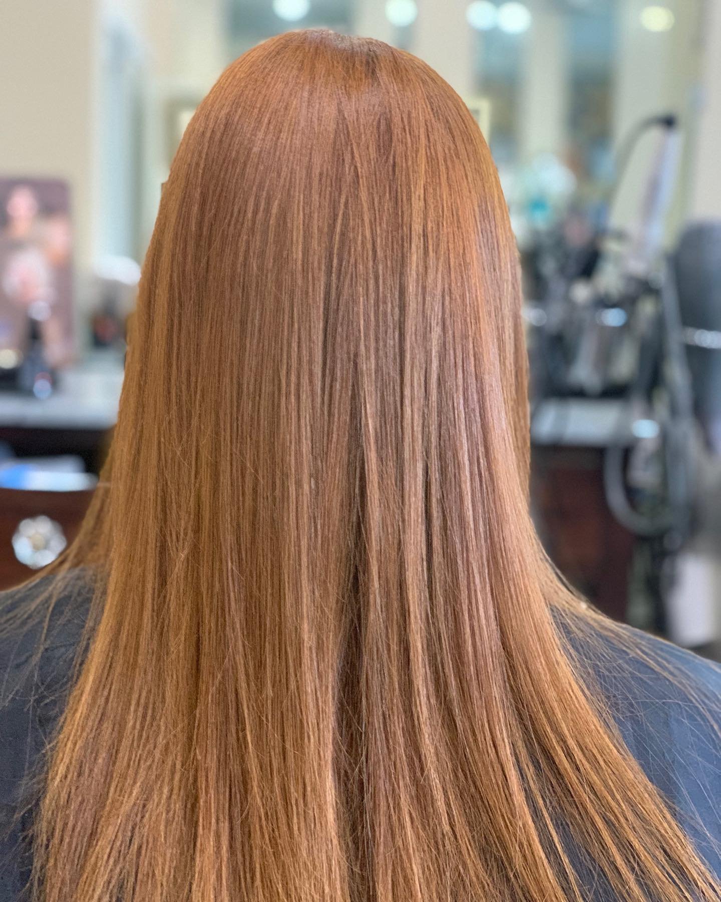 Back view of a person with long, straight, red hair.