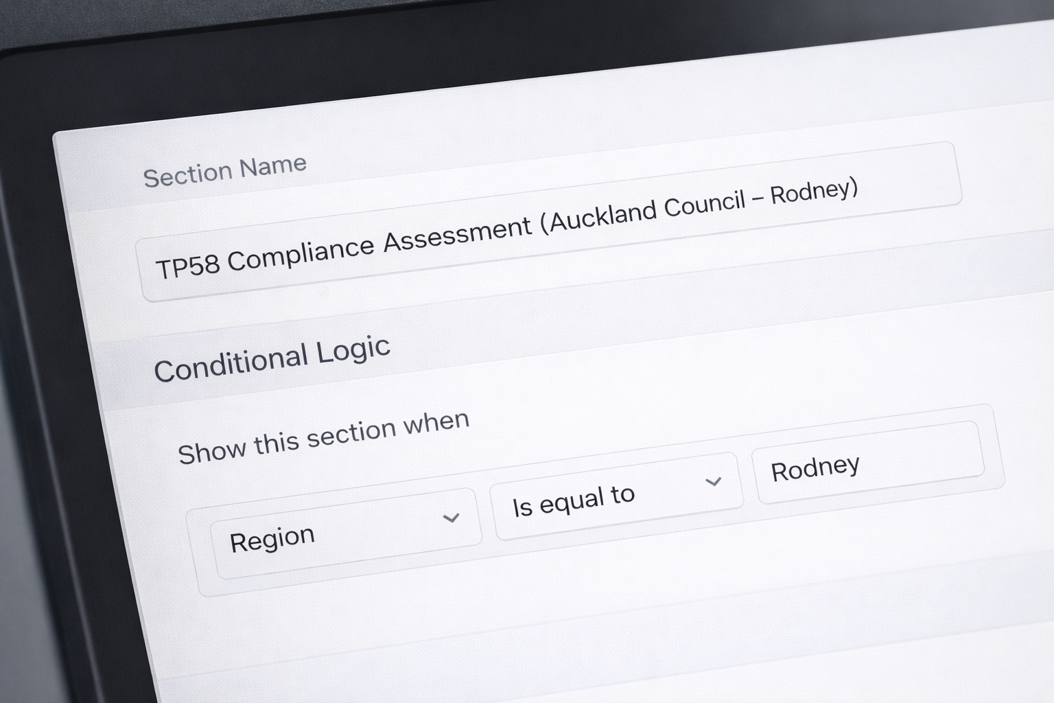 Close-up of a computer screen displaying a form section titled 'TP58 Compliance Assessment (Auckland Council - Rodney)', with a subheading 'Conditional Logic' showing a rule 'Show this section when Region is equal to Rodney'.