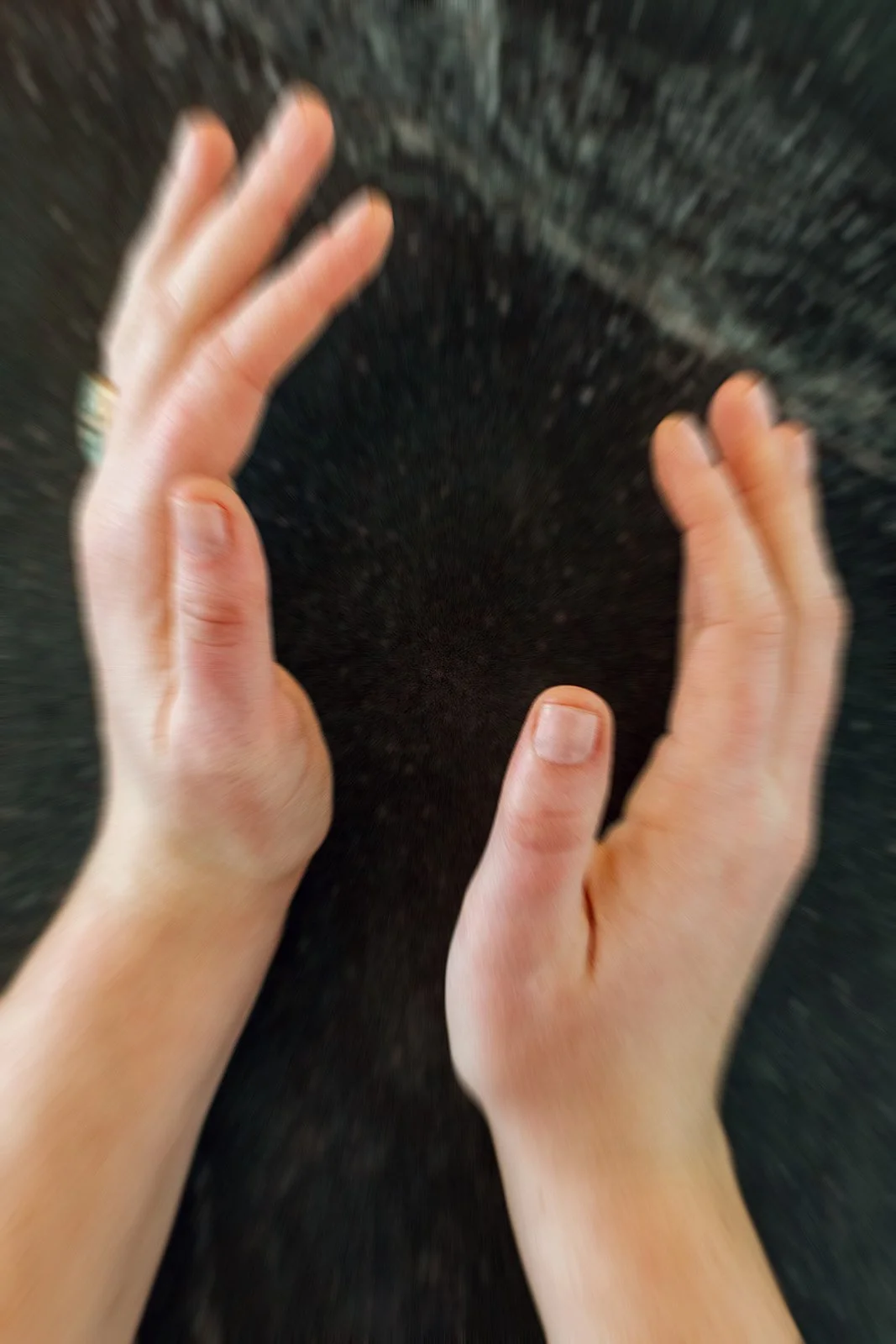 abstract decorative photo of hands holding space, with a blue ring on one hand
