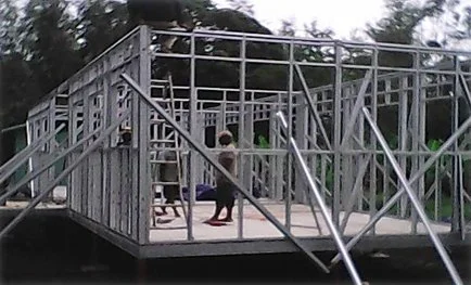 Construction workers assembling a steel frame for a building outdoors during daytime.