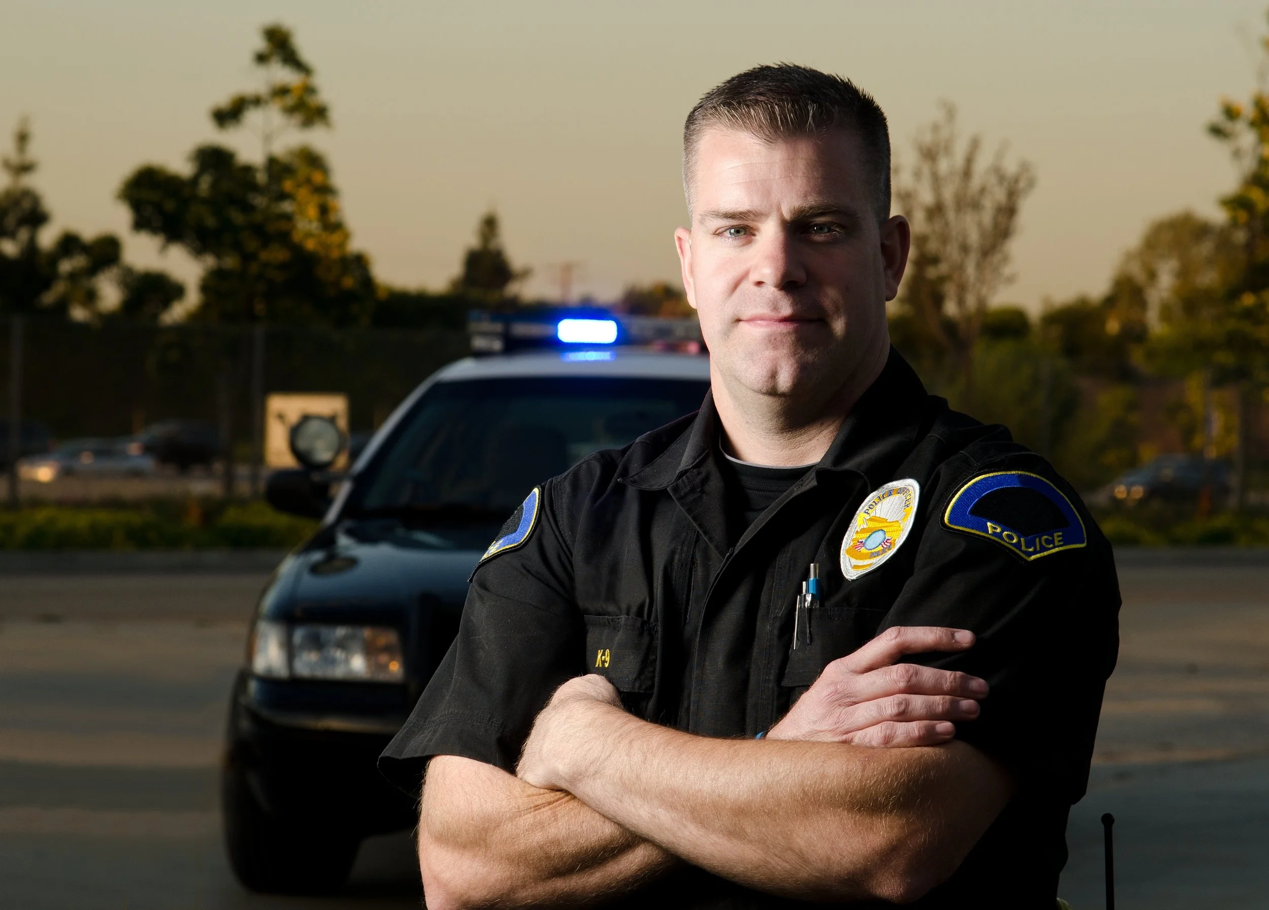 Police officer with car in background